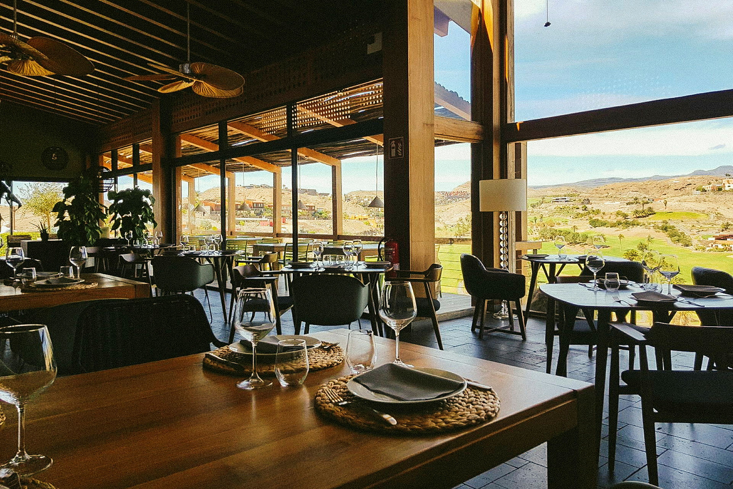 En restaurang med stora fönster och utsikt över landskapet. (AI-genererad text)