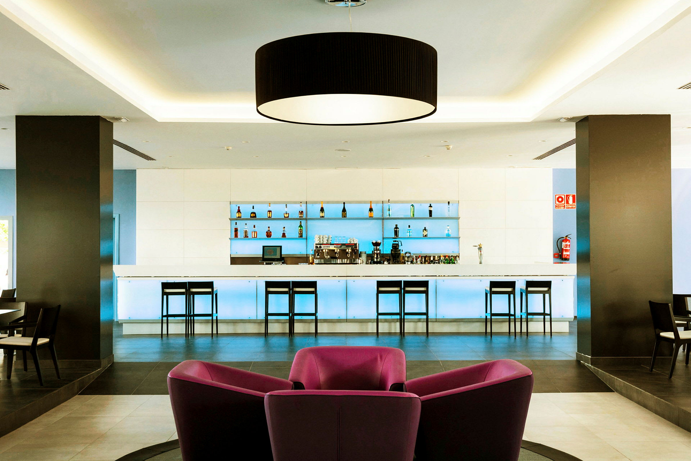 Modern hotellbar med stolar och flaskaexpo. (AI-genererad text)