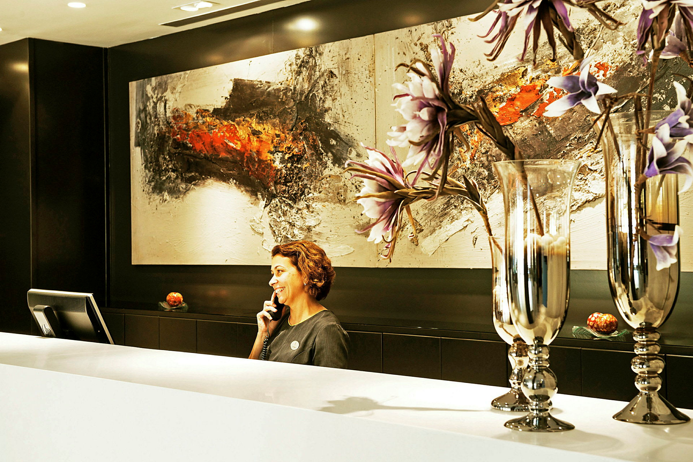 Reception med konstverk och dekorativa glasvaser med blommor. (AI-genererad text)
