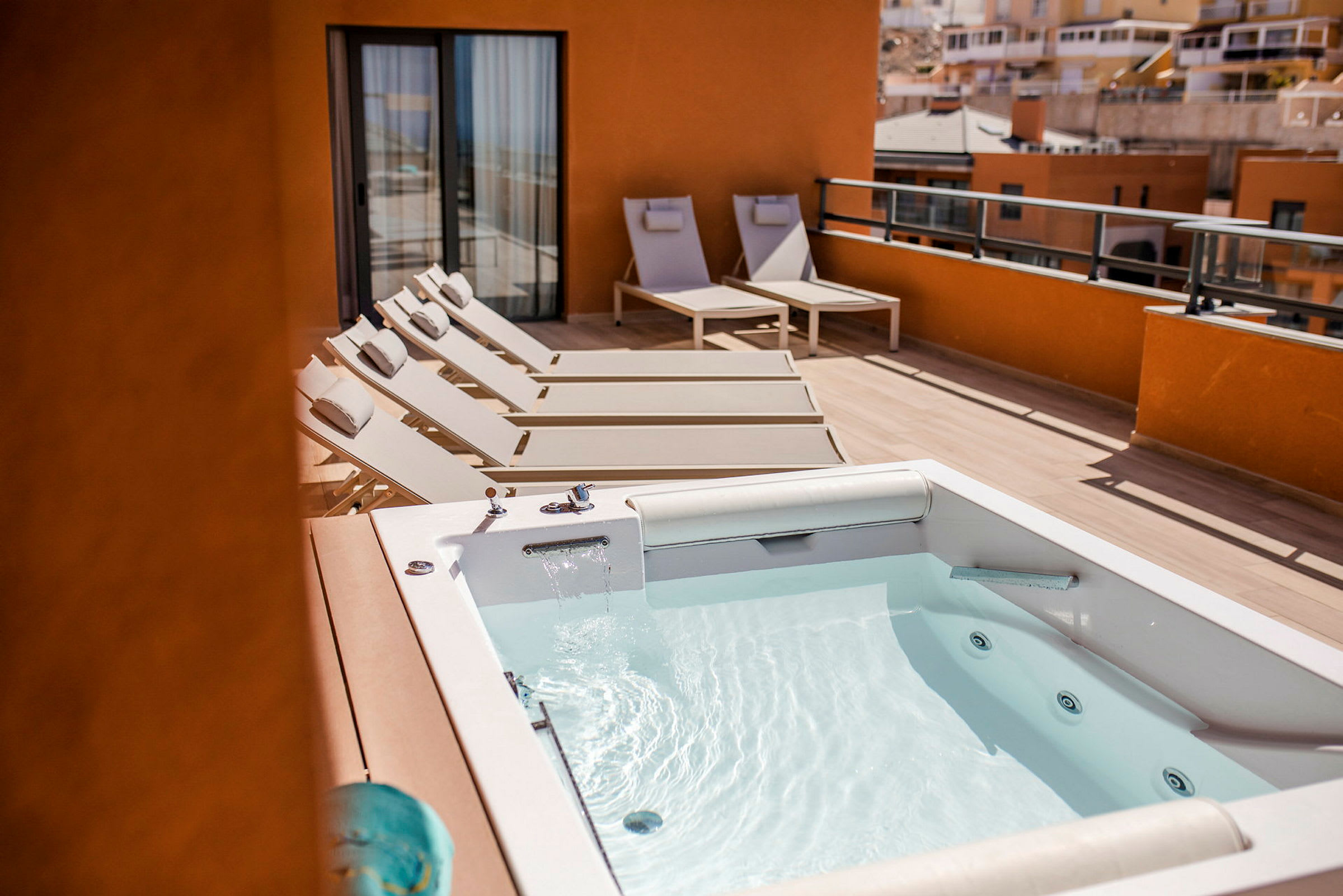 En terrass med bubbelpool och solstolar. (AI-genererad text)