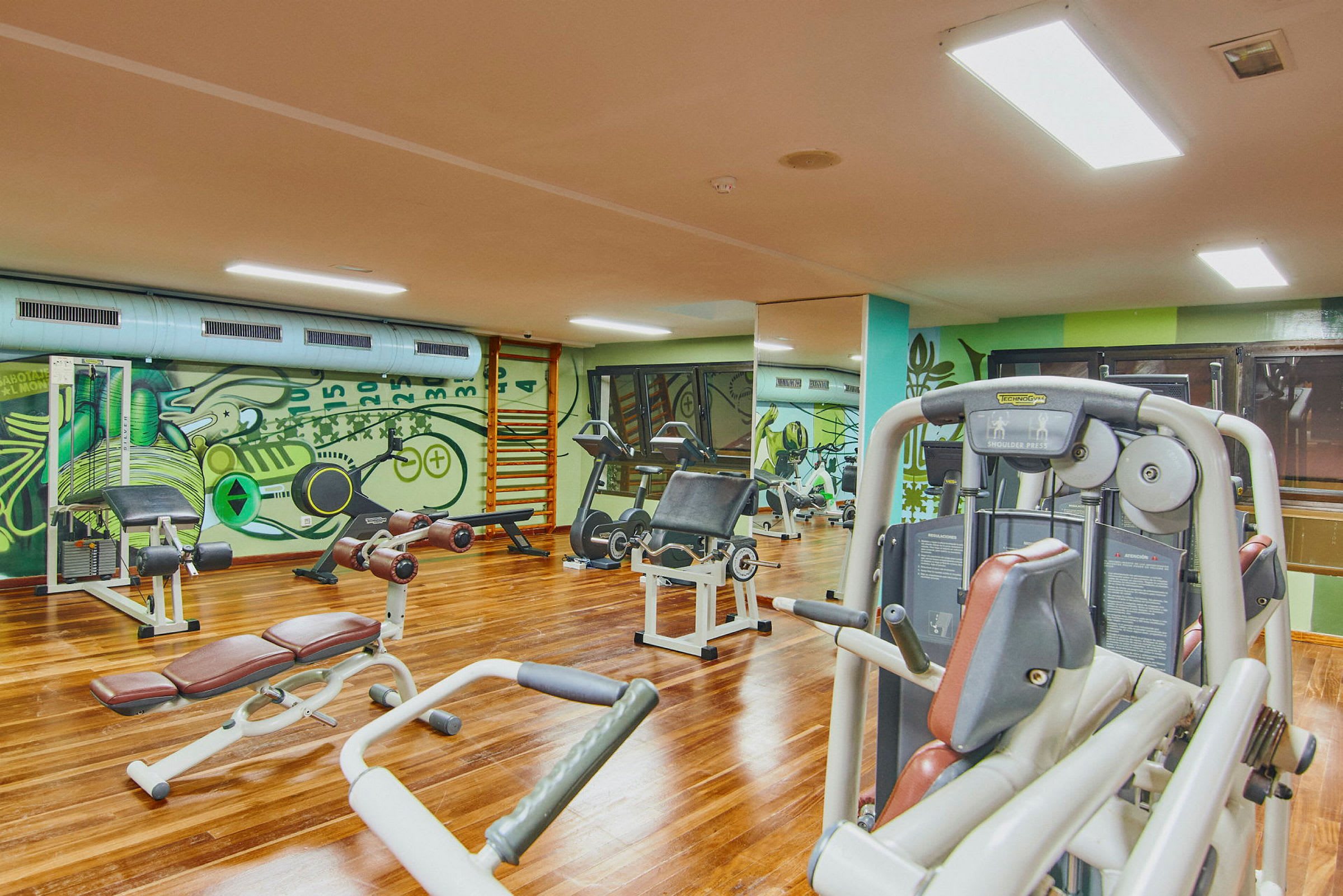 Ett gym med olika träningsmaskiner och utrustning. (AI-genererad text)