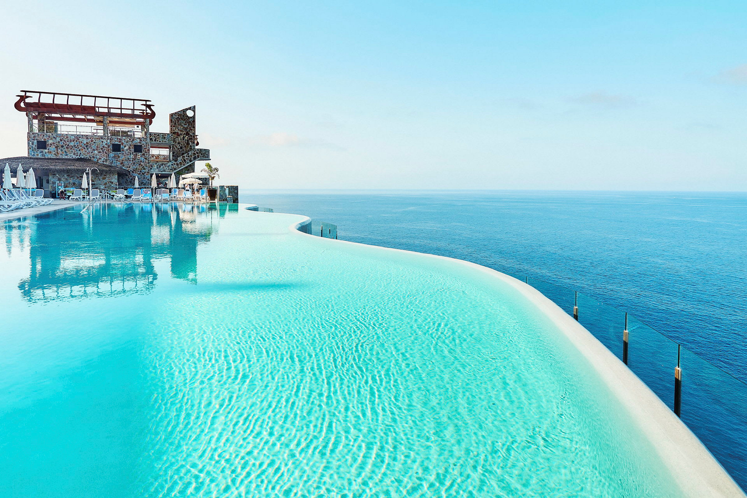 Infinitypool med klarblått vatten och utsikt över havet. (AI-genererad text)
