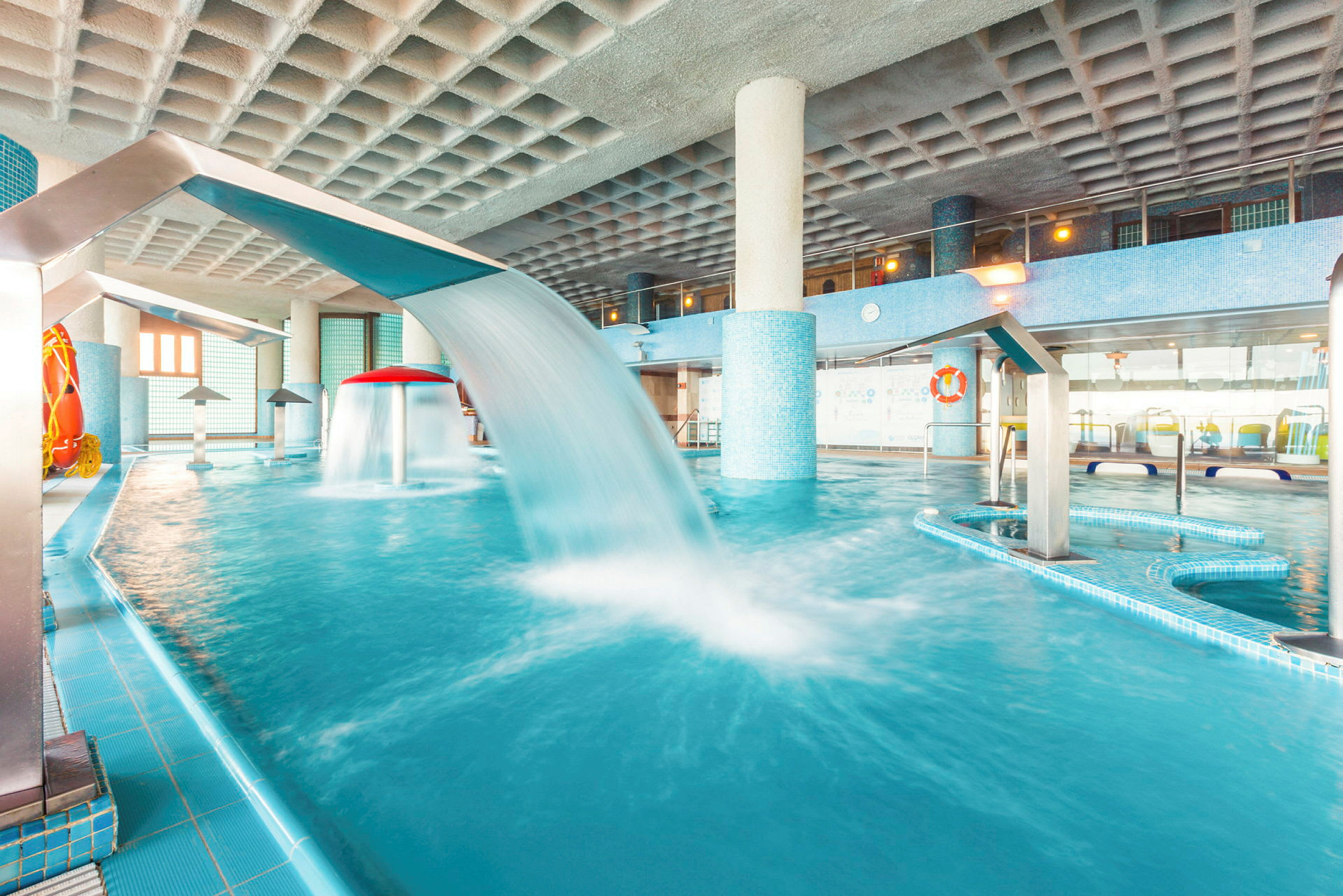 En inomhuspool med vattenströmmar och bubbelbad. (AI-genererad text)