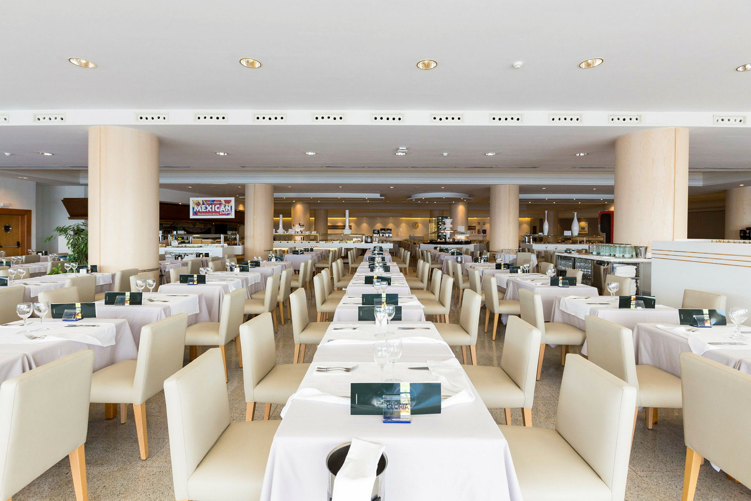 Interiör av en restaurang med dukade bord och stolar arrangerade i rader. (AI-genererad text)