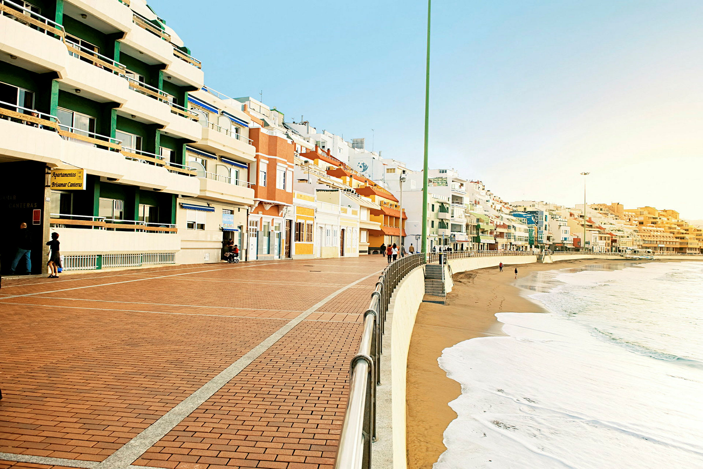 En strandpromenad med färgglada byggnader längs kusten. (AI-genererad text)