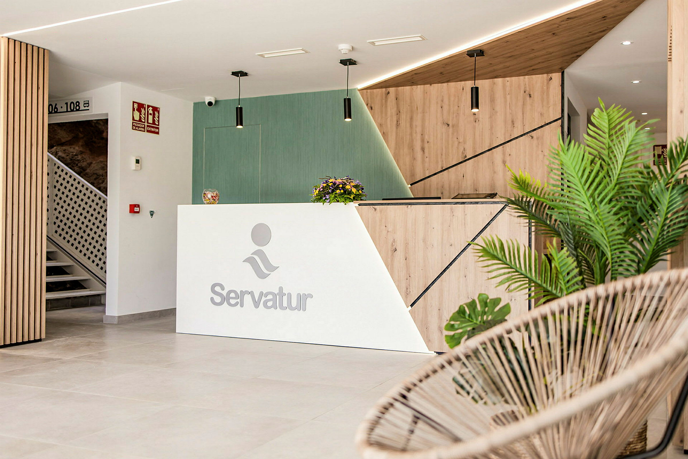 Reception med Servatur-logotyp, modern design och prydnadsväxter. (AI-genererad text)