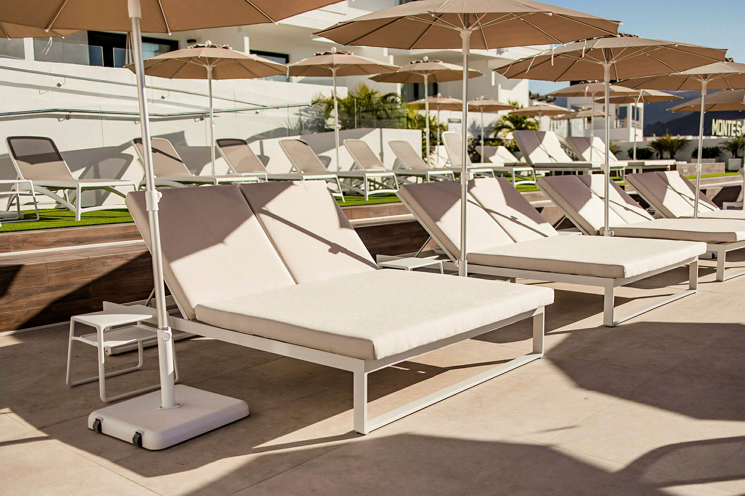 Solstolar med parasoll vid en pool. (AI-genererad text)