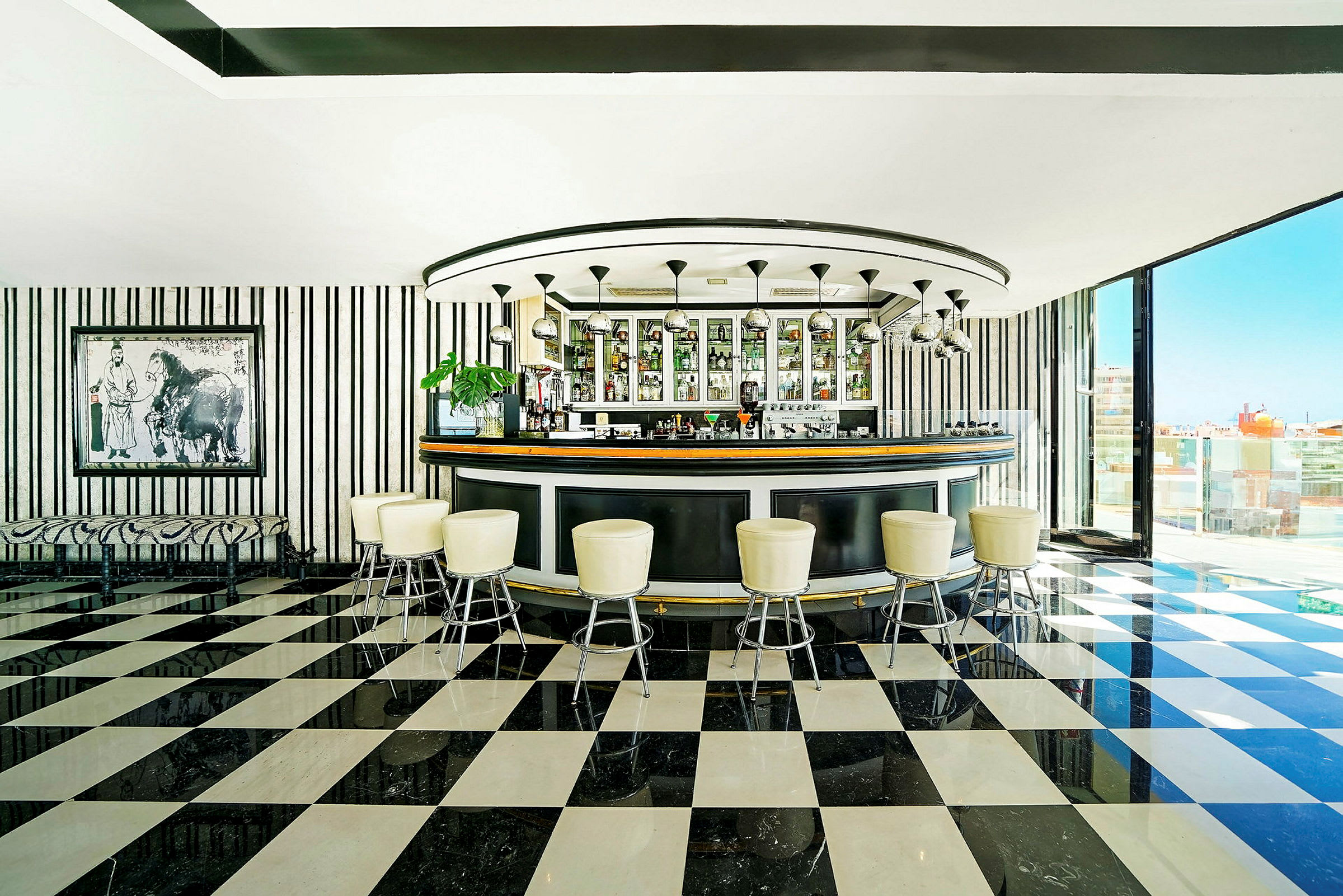 En bar med runt design, randiga väggar och schackbrätsmönstrat golv. (AI-genererad text)