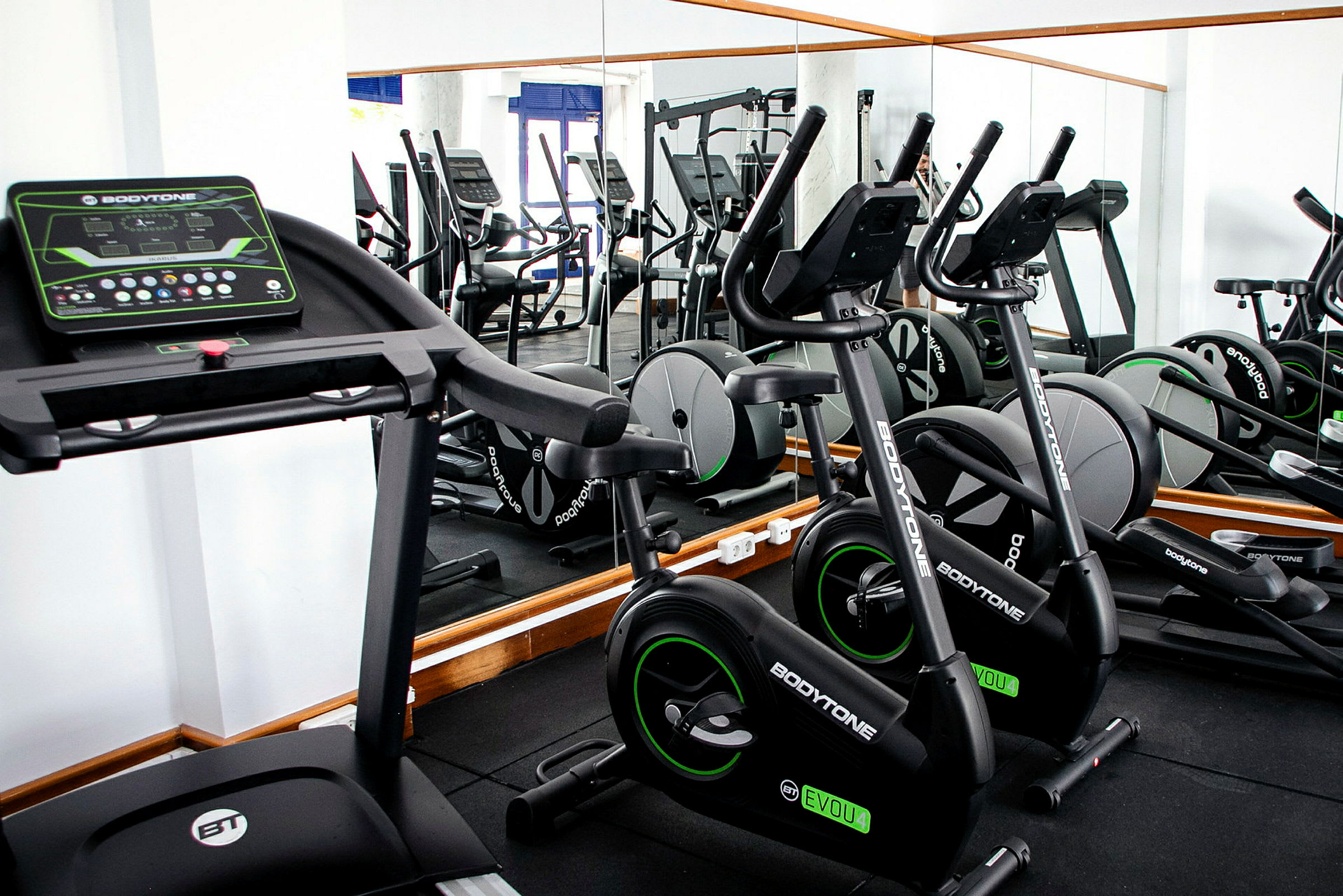 Gym med träningsmaskiner, inklusive löpband och träningscykel. (AI-genererad text)