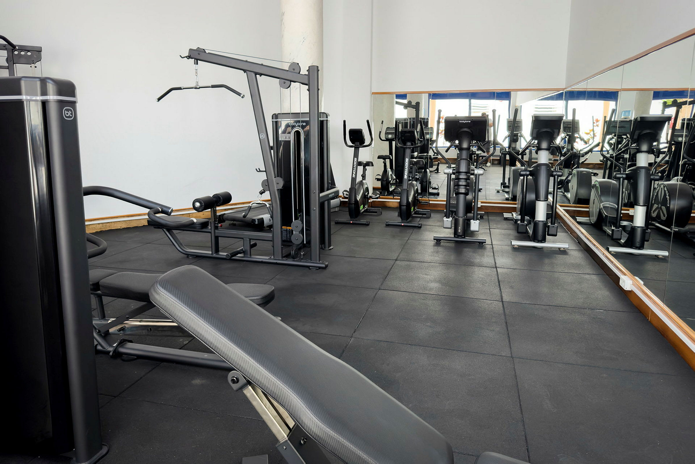 Ett gym med träningsutrustning som motionscyklar och viktmaskiner. (AI-genererad text)