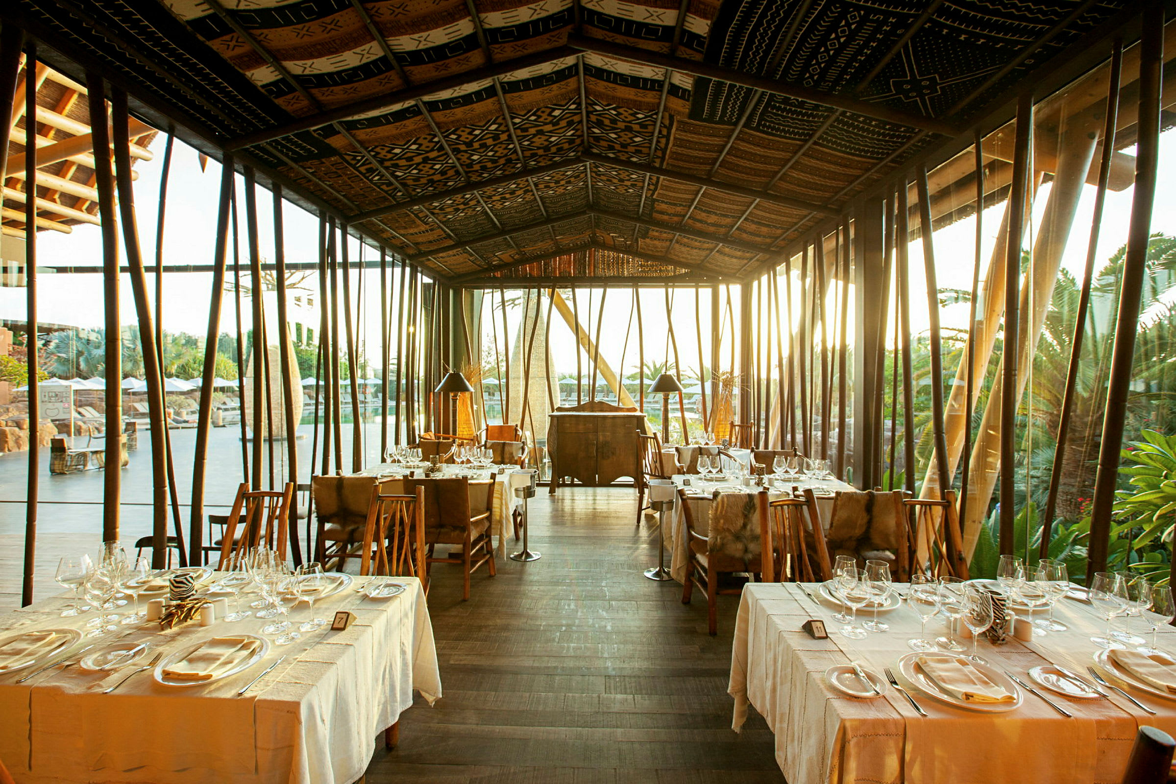 En restaurang med dukade bord och glasväggar som släpper in naturligt ljus. (AI-genererad text)
