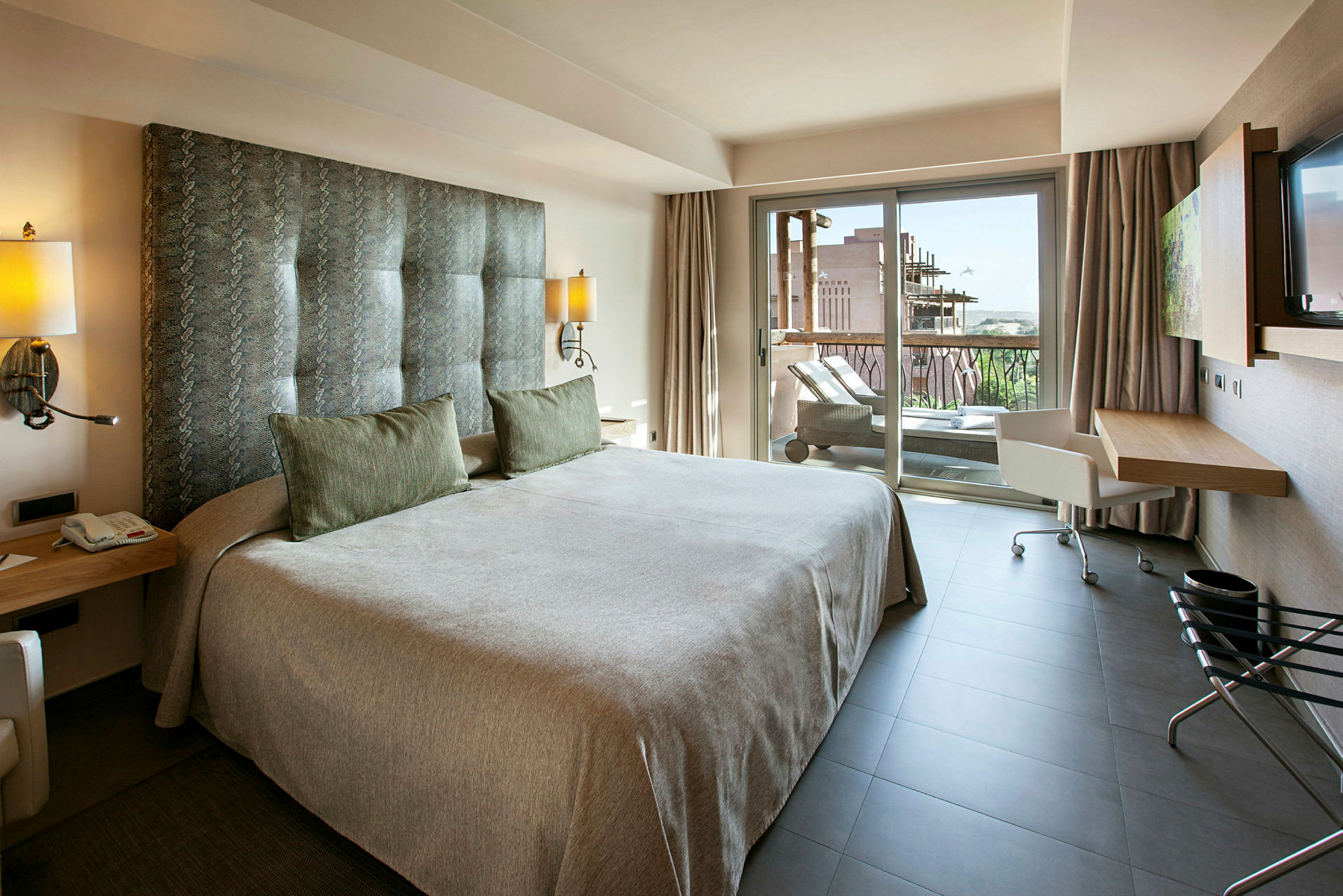 Modernt hotellrum med en dubbelsäng och tillgång till en balkong. (AI-genererad text)