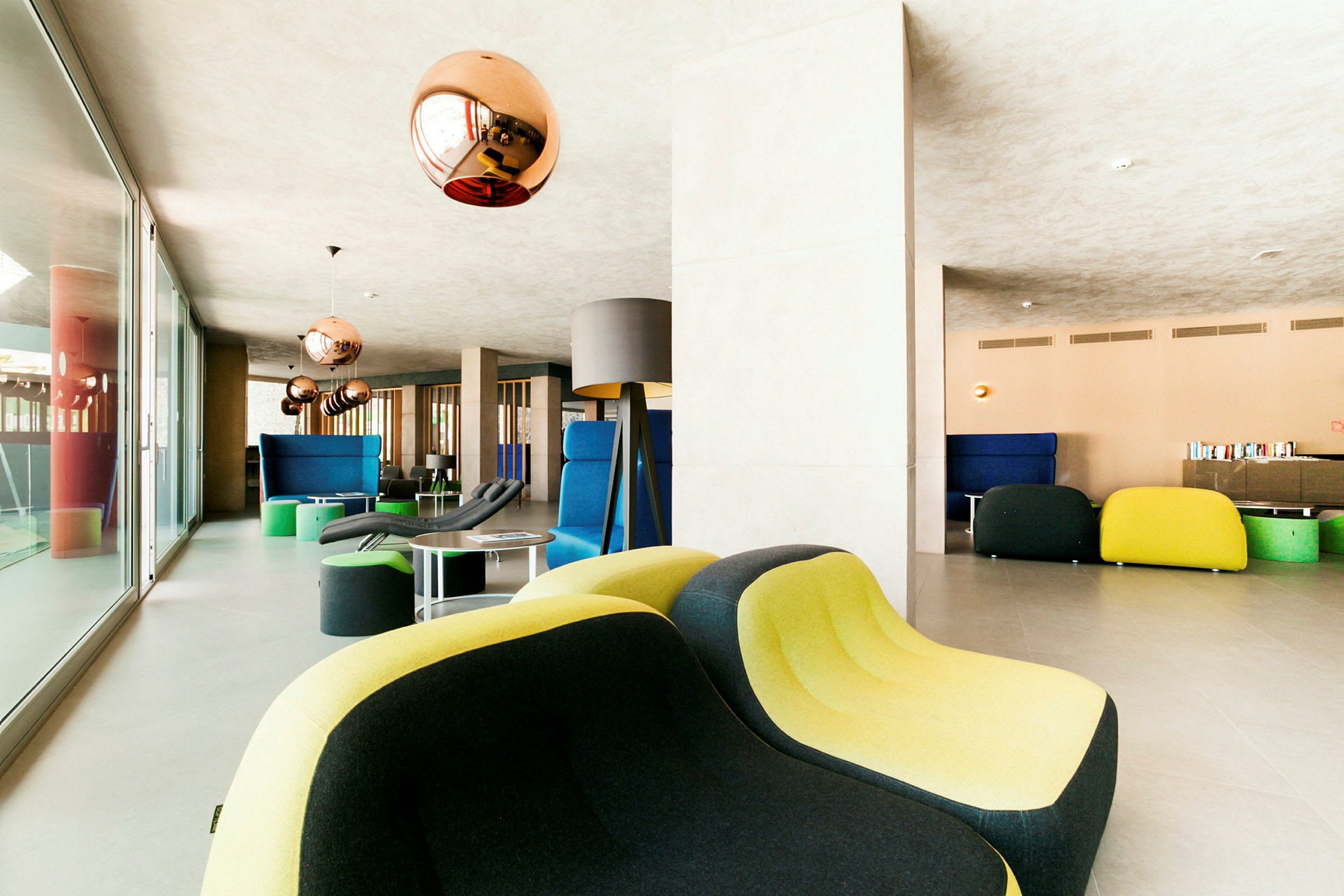Modern lounge med färgglada möbler och kopparfärgade lampor. (AI-genererad text)
