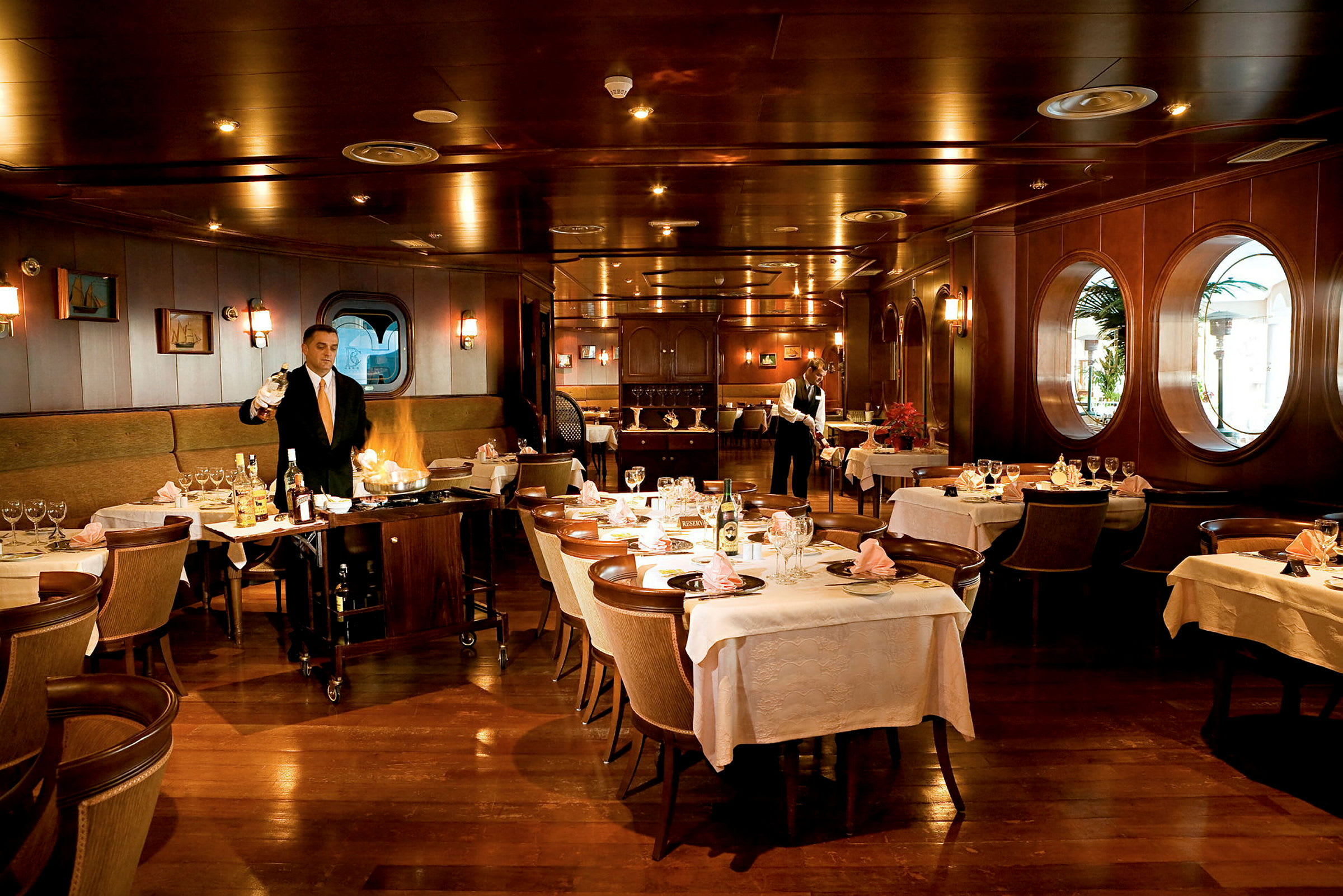 Interiör av en elegant restaurang med dukade bord och träpaneler. (AI-genererad text)