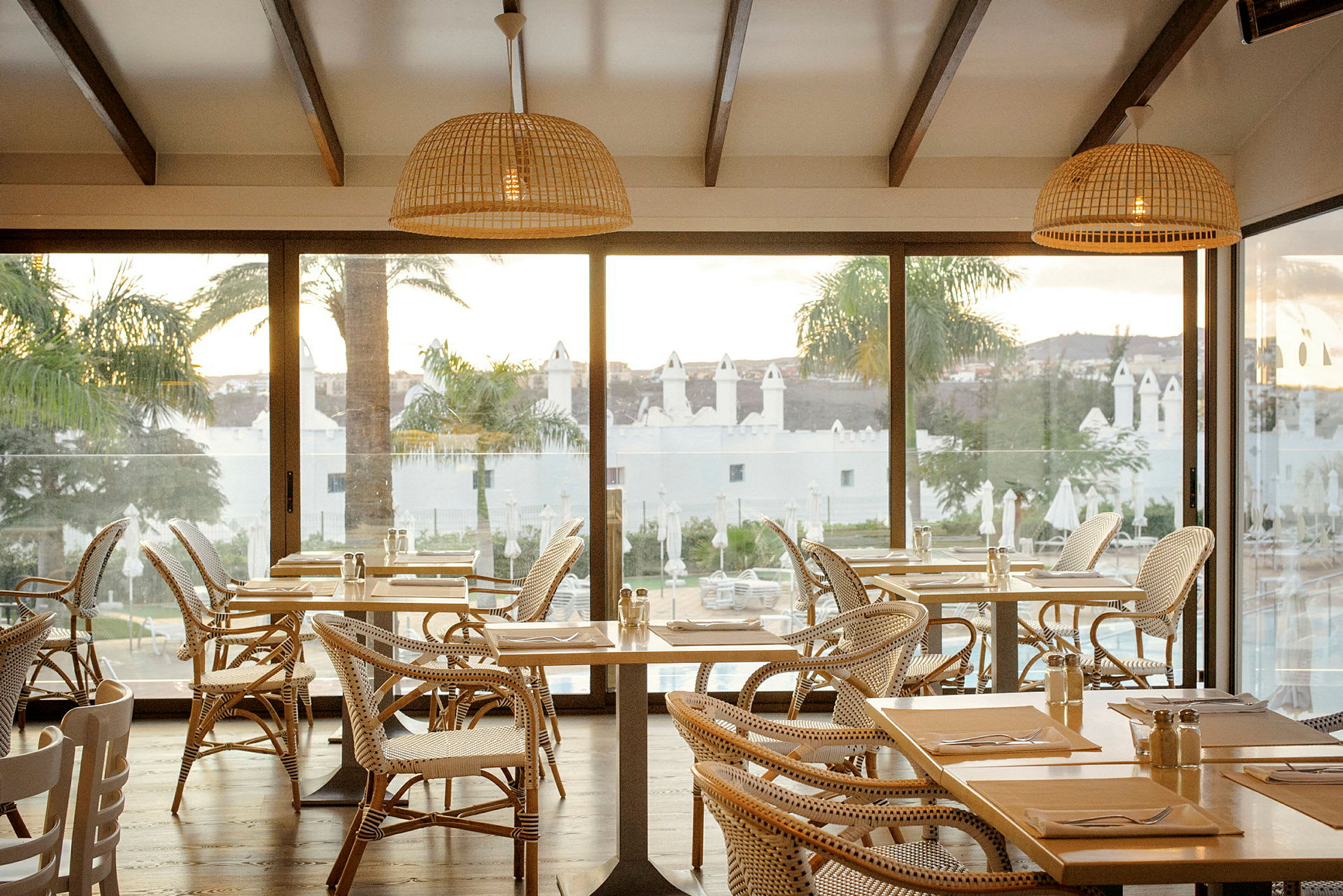 Restaurang med stora fönster och utsikt över palmer. (AI-genererad text)