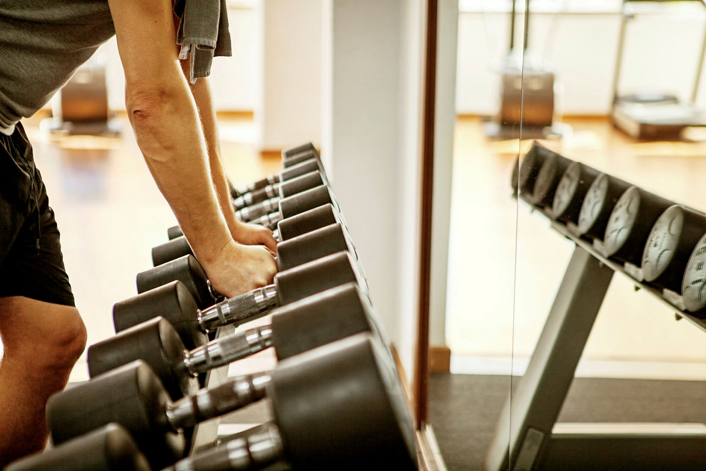 En person håller i hantlar i ett gym. (AI-genererad text)