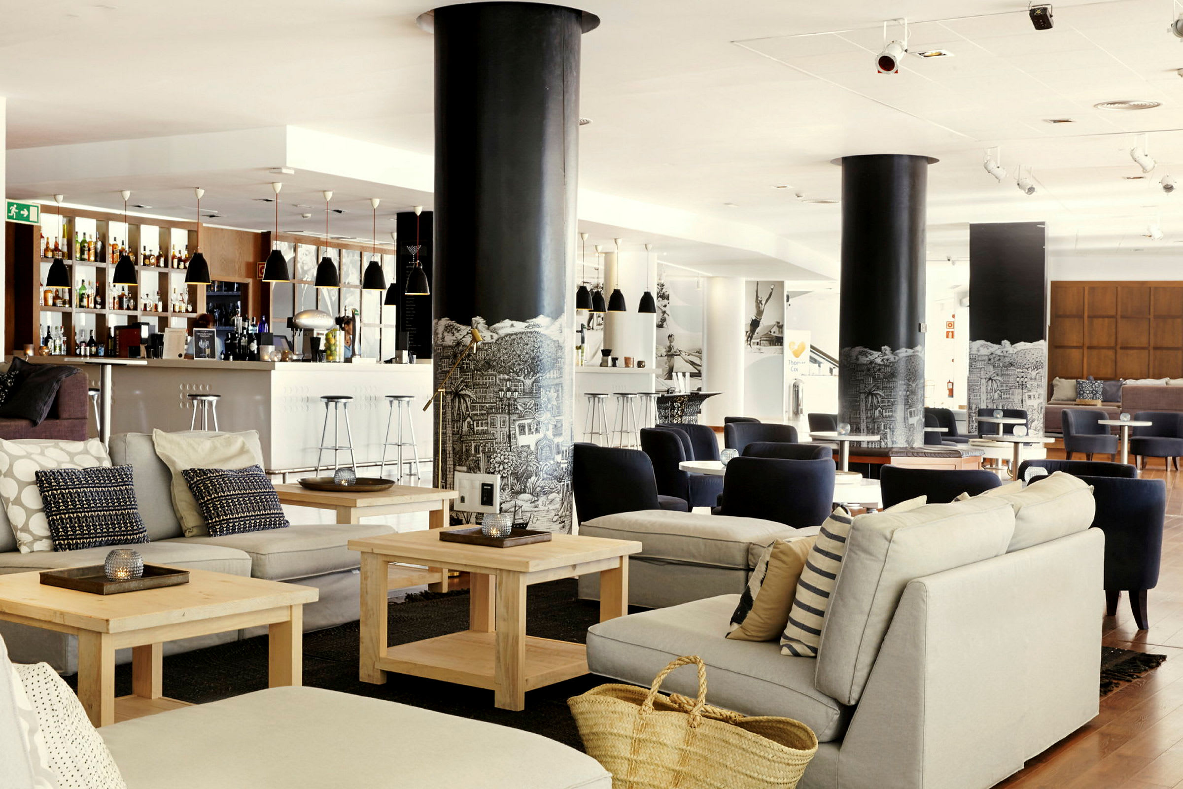Ljust och modern loungeområde med sittgrupper och en bar. (AI-genererad text)