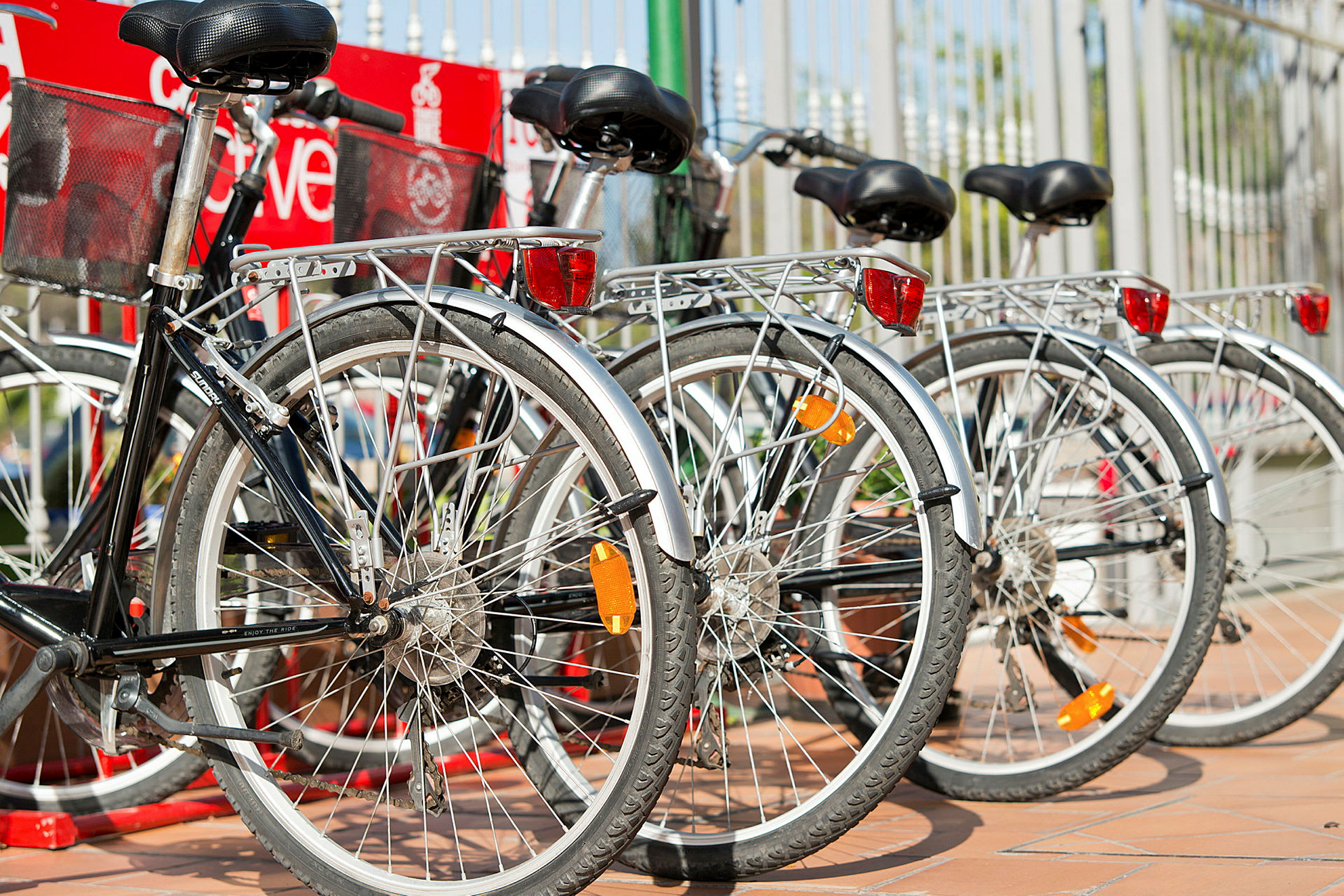 En rad av parkerade cyklar vid ett räcke. (AI-genererad text)