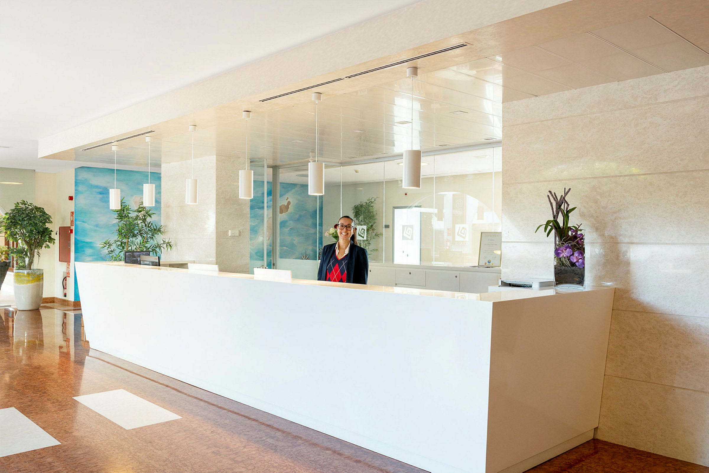 En vit receptionsdisk med växter och inredning. (AI-genererad text)
