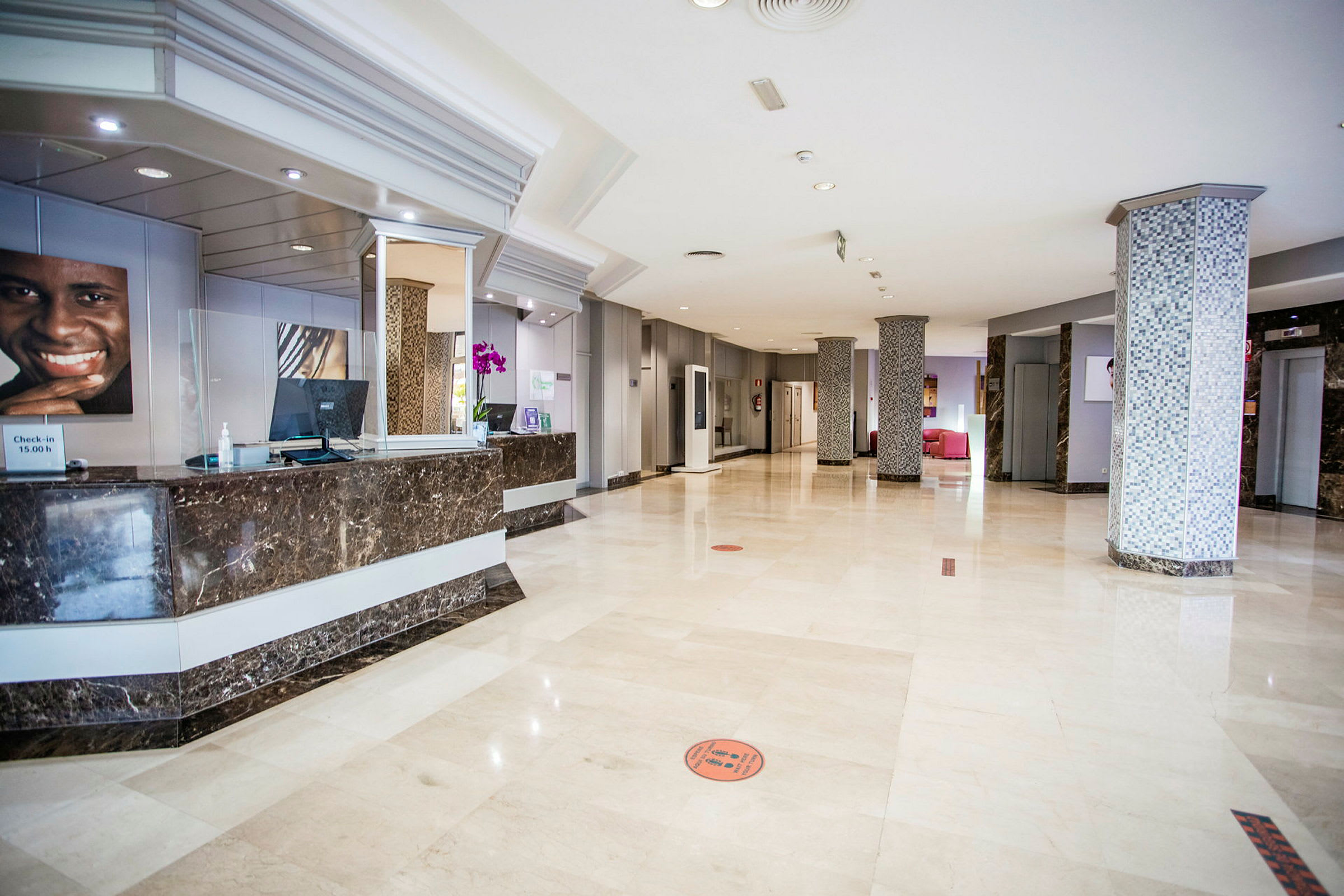 Hotellobby med marmorgolv och reception. (AI-genererad text)