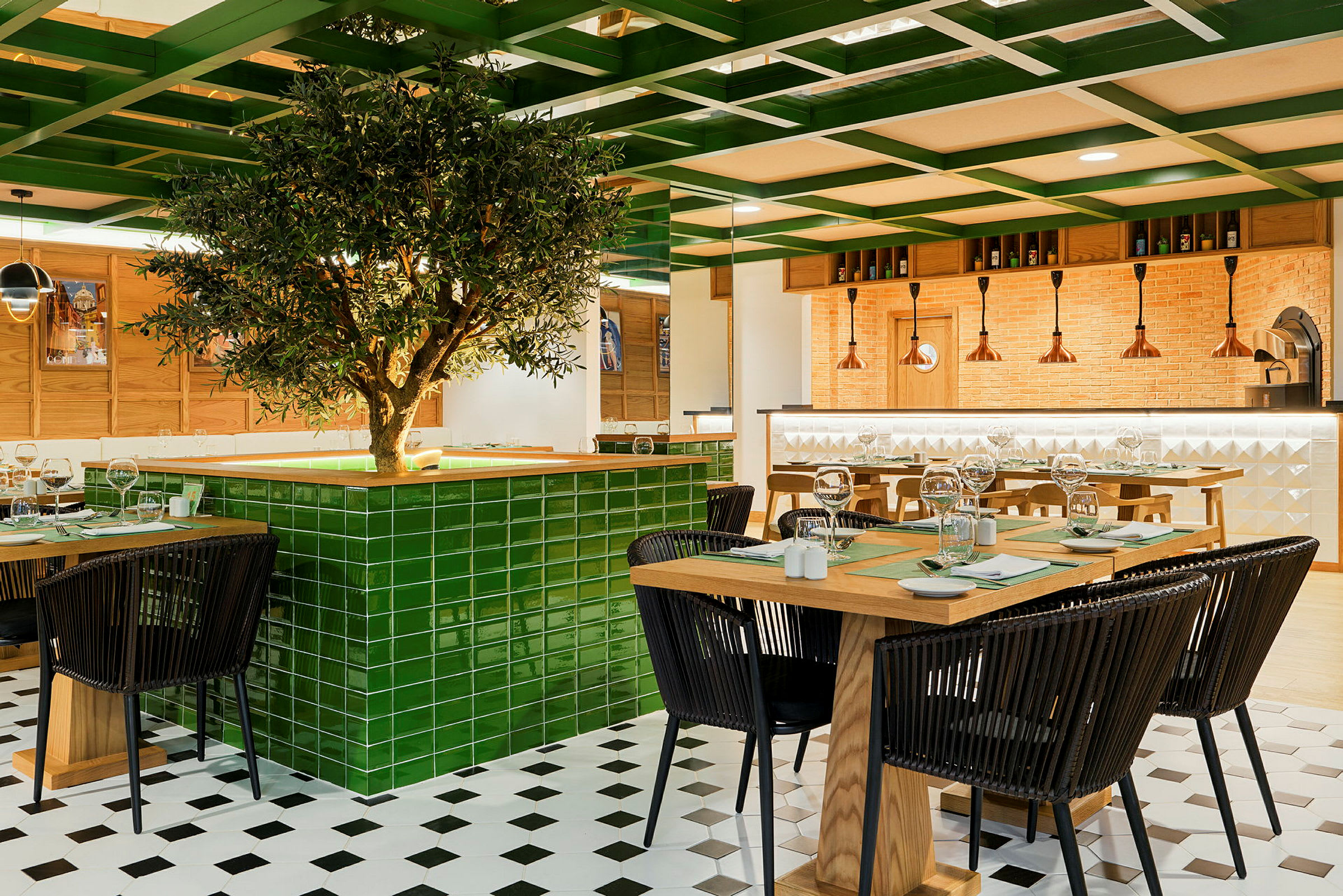 En modern restaurang med träbord och svarta stolar, centralt dekorerad med ett grönt trä med kaklad bas. (AI-genererad text)