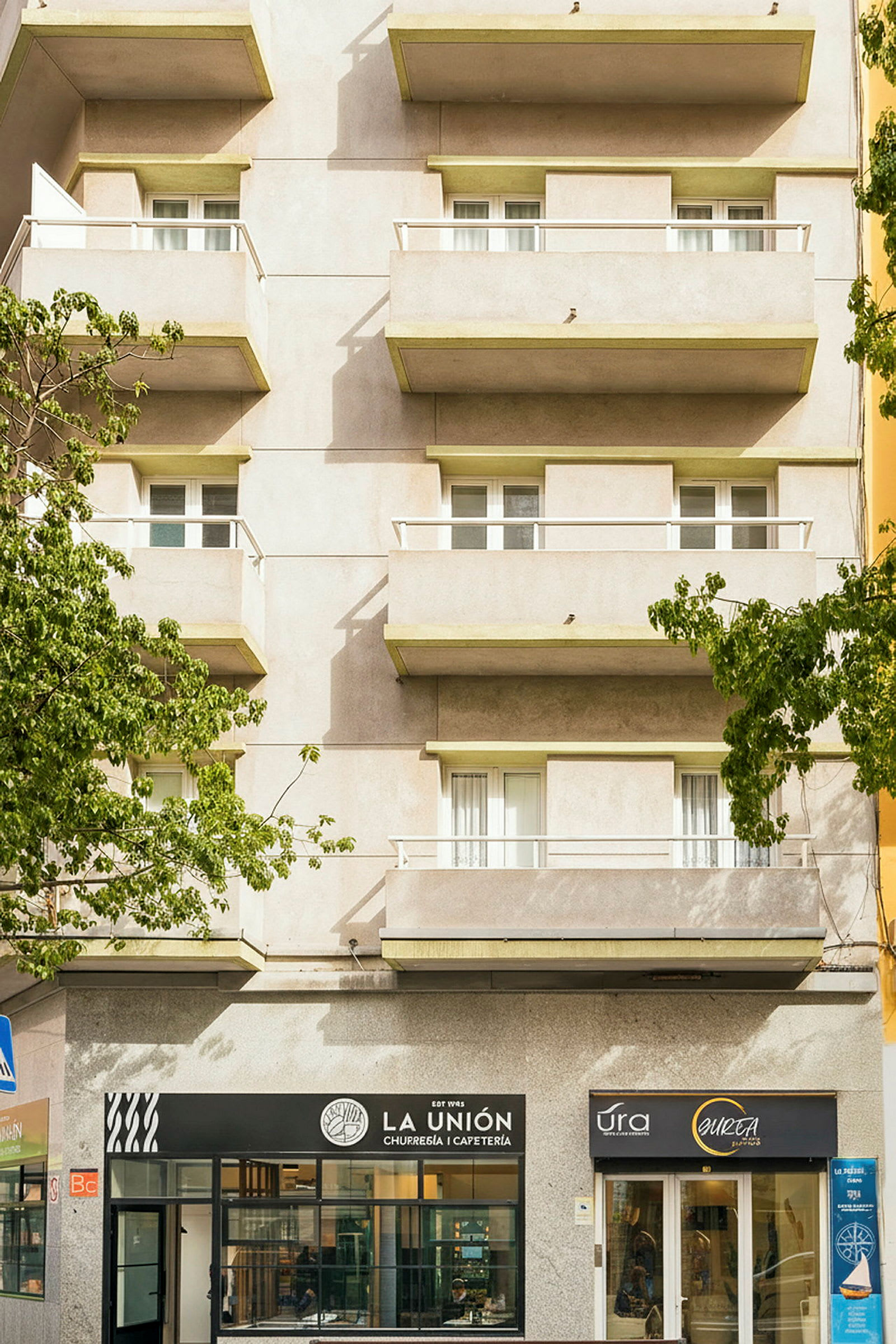 Flerbostadshus med flera balkonger ovanför kaféer. (AI-genererad text)