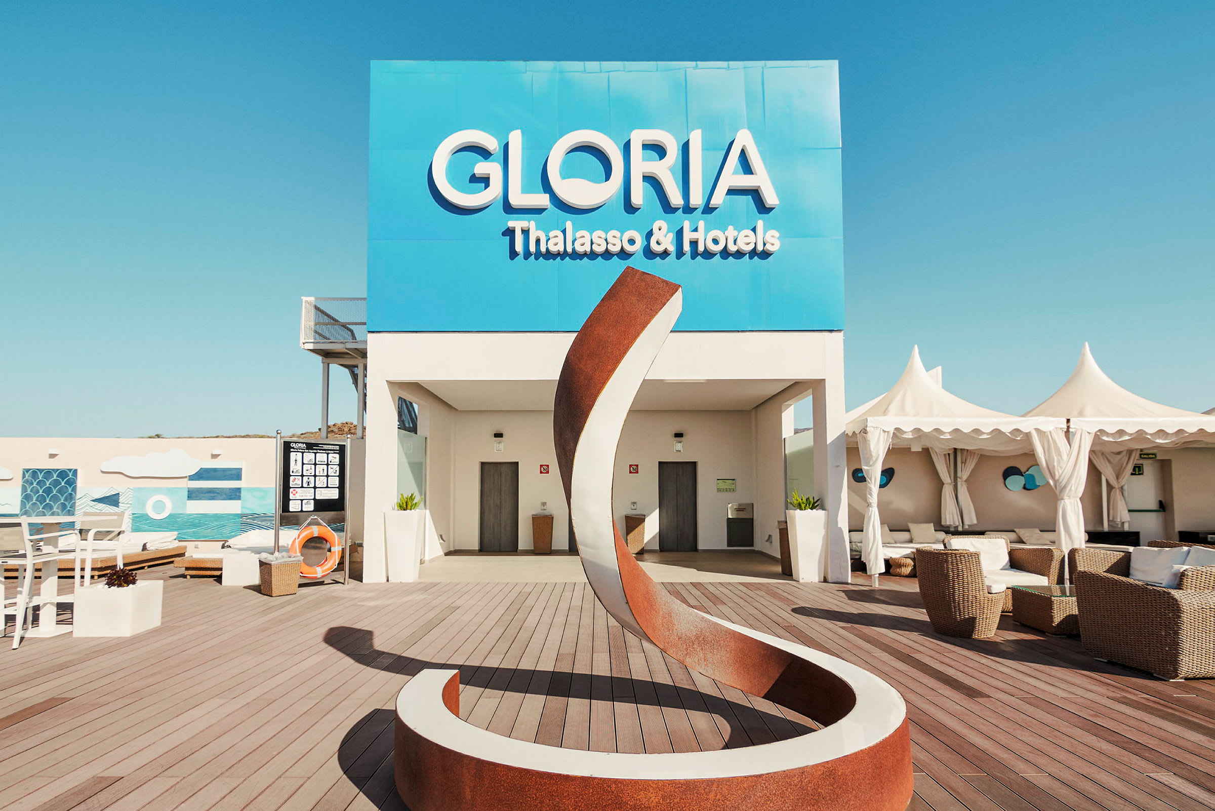 Utomhusområde vid Gloria Thalasso & Hotels med modern skulptur och sittplatser. (AI-genererad text)