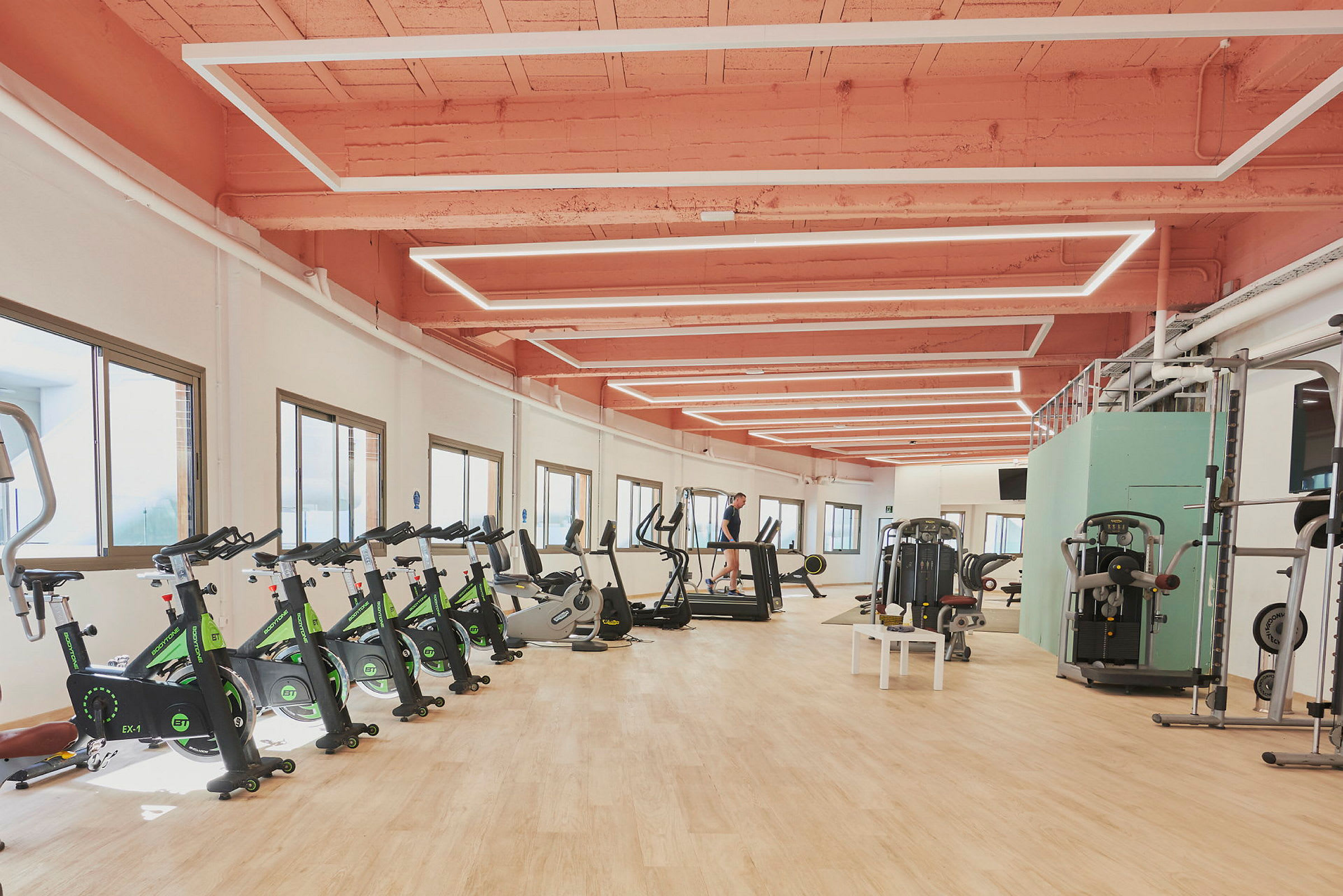 Ett gym med träningsutrustning, inklusive motionscyklar, löpband och styrketräningsmaskiner. (AI-genererad text)