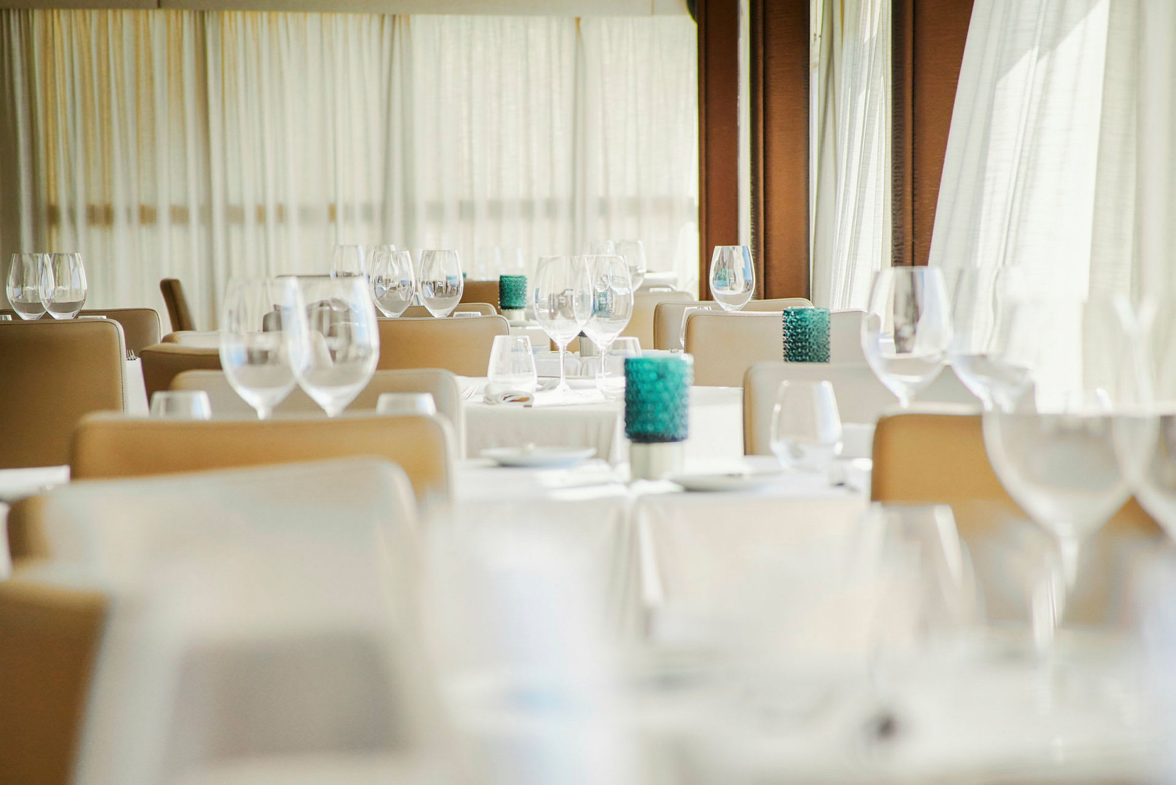 Ett elegant restaurangområde med dukade bord, sittplatser och dekorativa glas. (AI-genererad text)