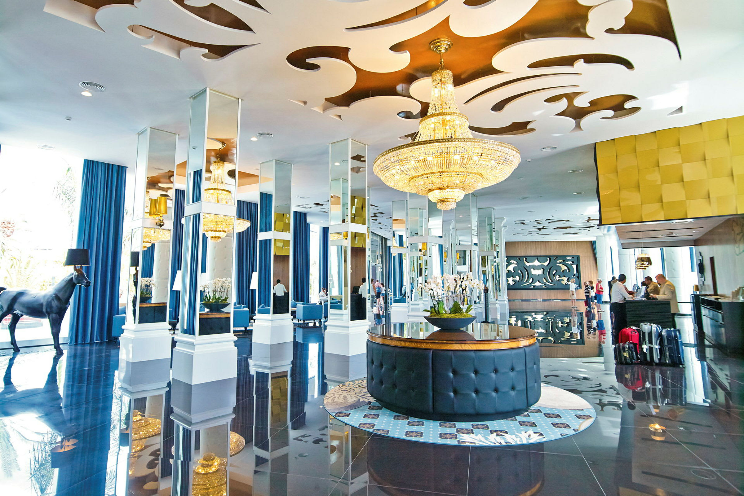 Hotellobby med elegant inredning, ljuskronor och speglar. (AI-genererad text)