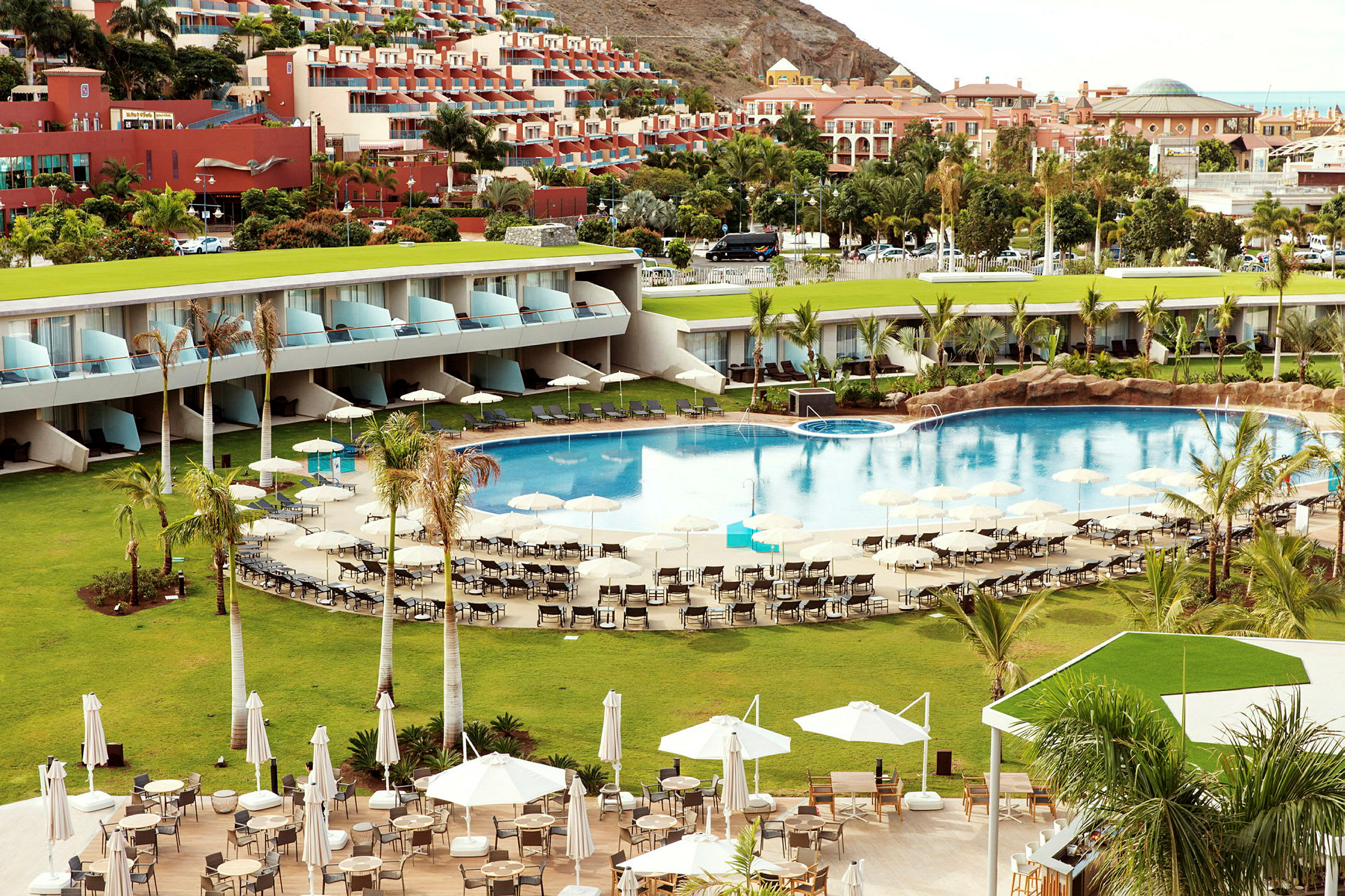 Hotellområde med pool, solstolar och parasoll. (AI-genererad text)