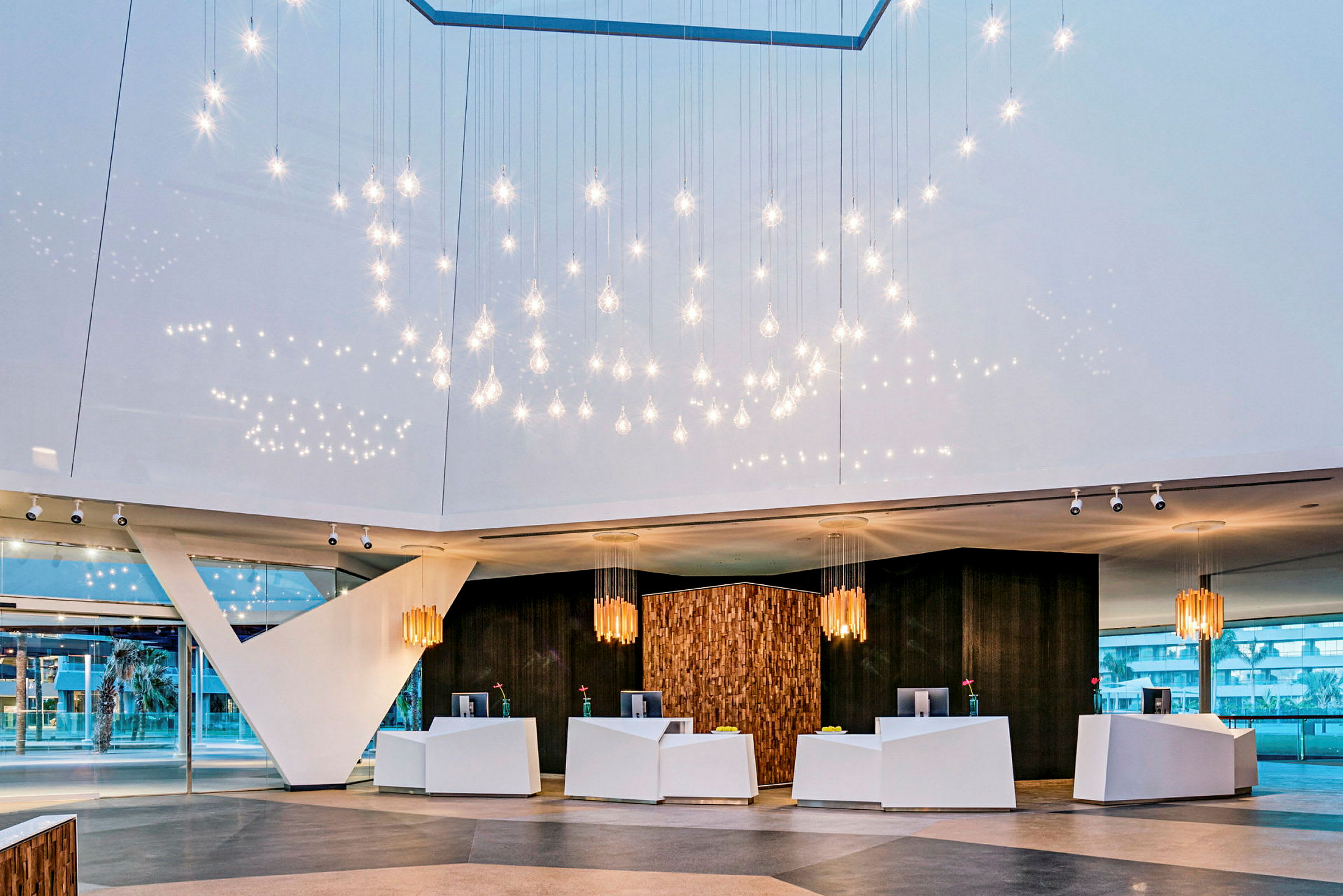 Hotellets lobby med modern inredning och hängande ljusdekorationer. (AI-genererad text)