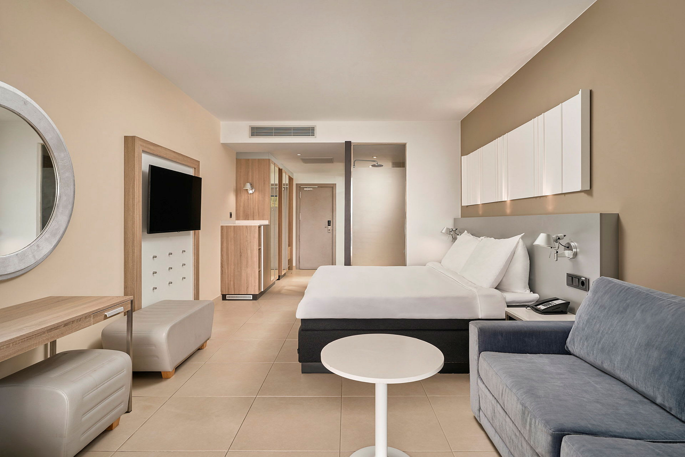 Hotellrum med en dubbelsäng, soffa och skrivbord. (AI-genererad text)