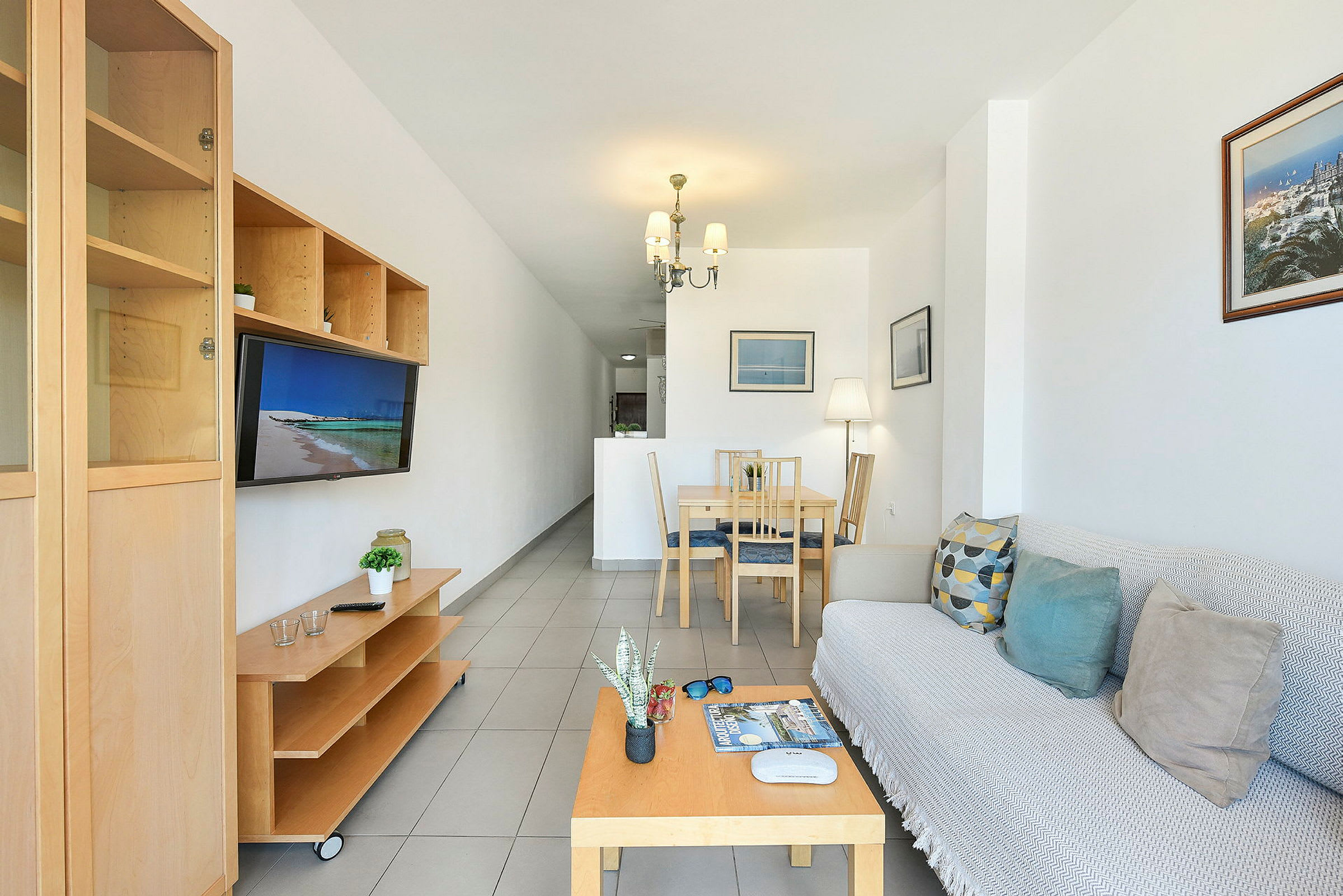 Ett vardagsrum med soffa, soffbord, matbord och TV. (AI-genererad text)