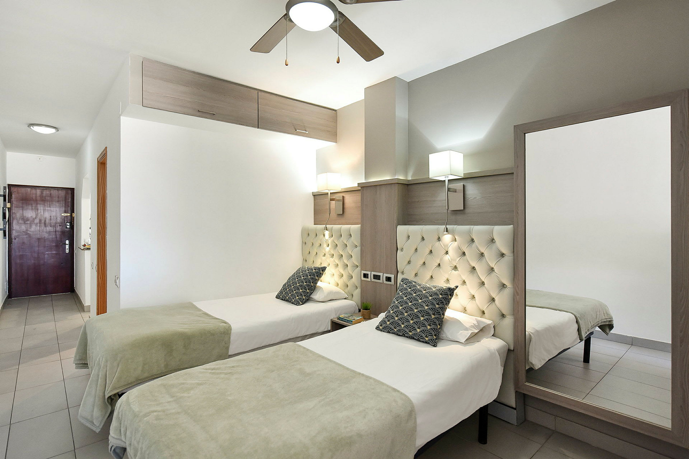 Två enkelsängar i ett hotellrum med ljus och modern inredning. (AI-genererad text)
