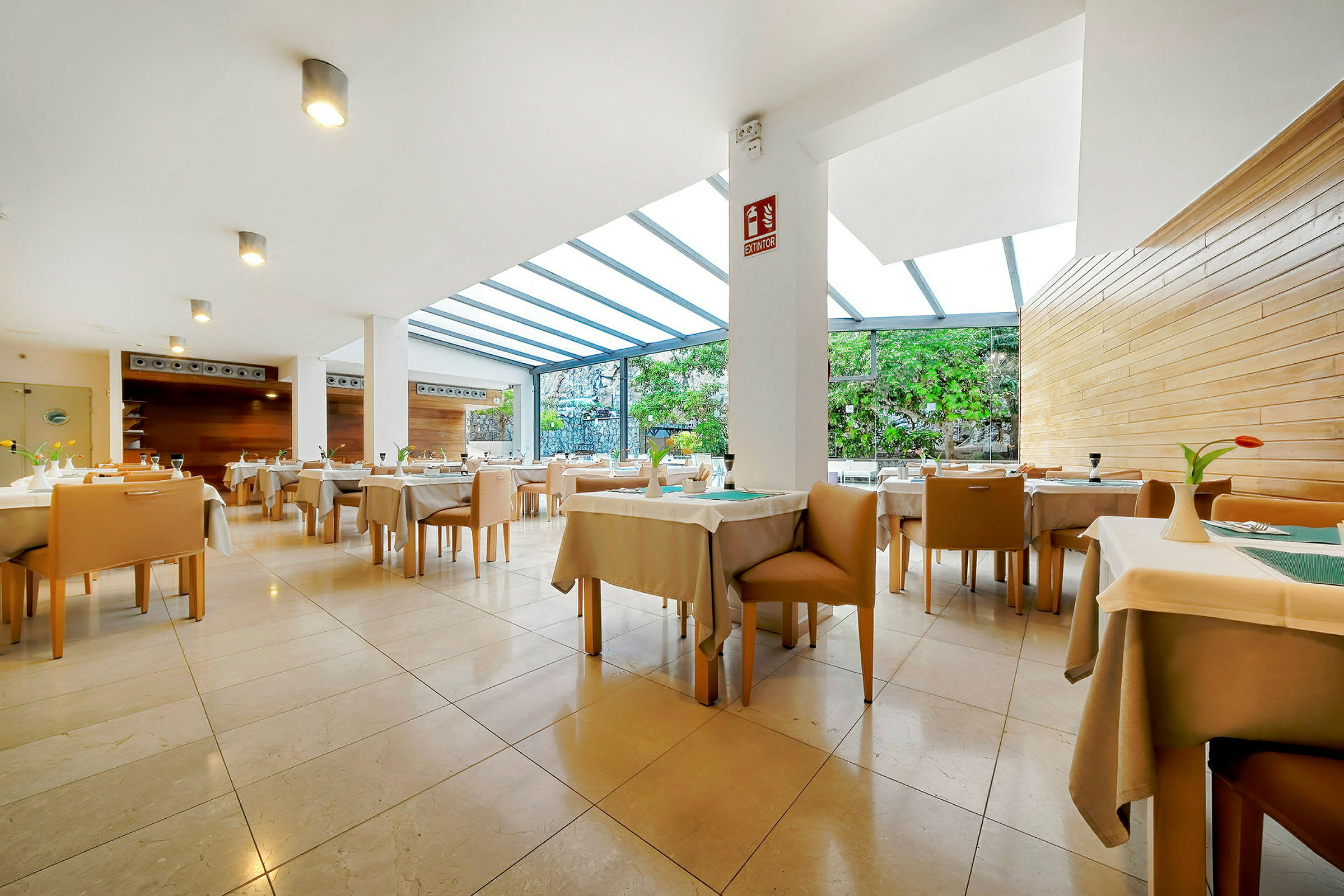 En ljus restaurang med vita borddukar och beige stolar. (AI-genererad text)