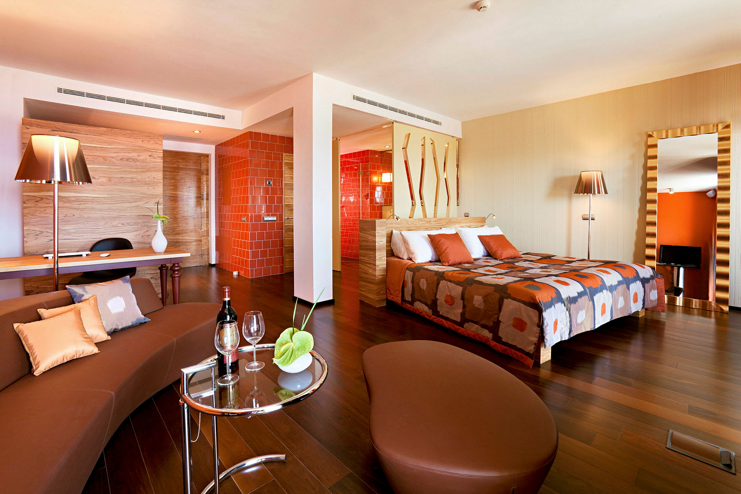 Ett hotellrum med modern inredning, orange detaljer och en dubbelsäng. (AI-genererad text)