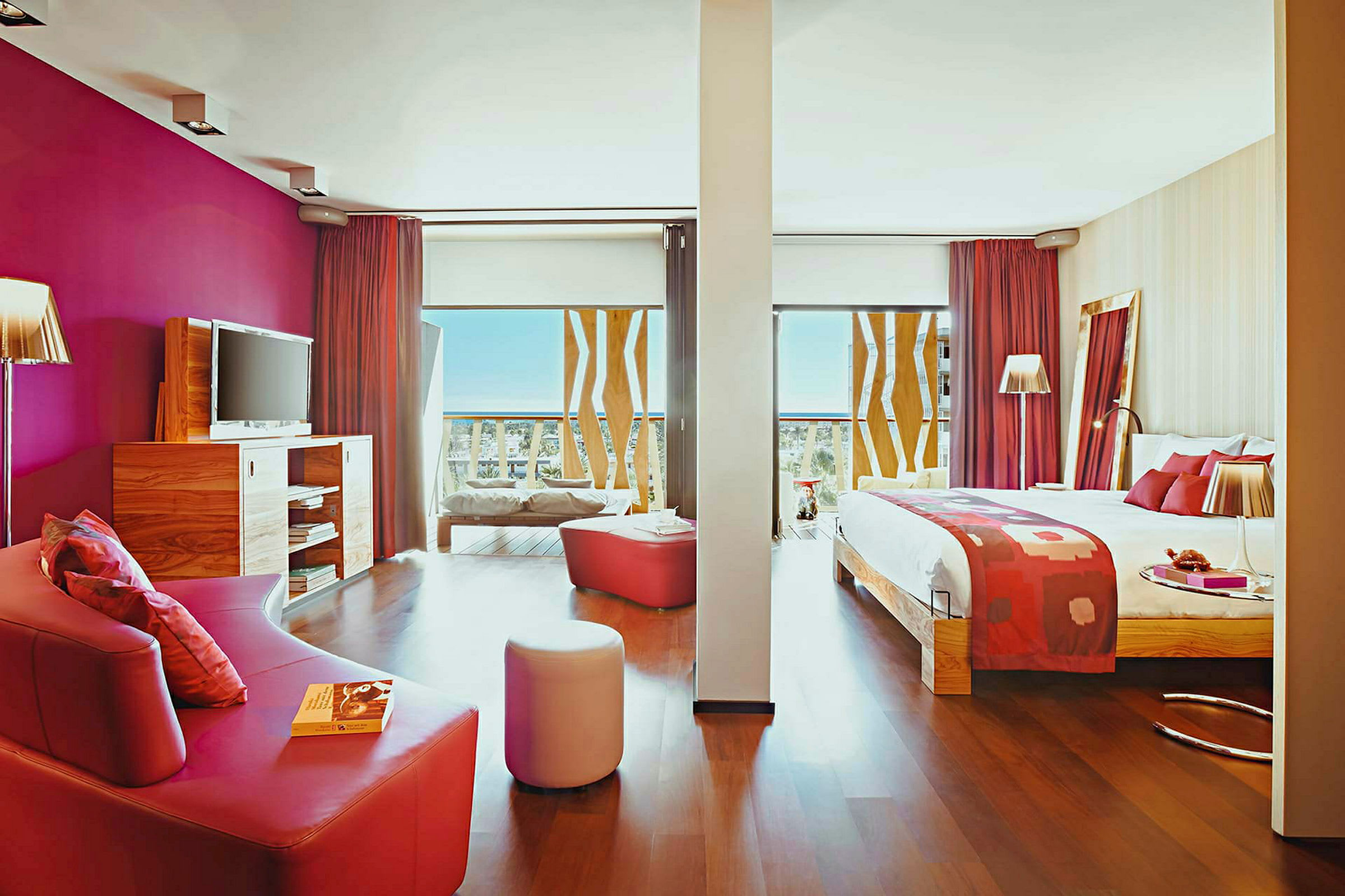 Hotellrum med säng, soffa och modern inredning med rosa detaljer. (AI-genererad text)
