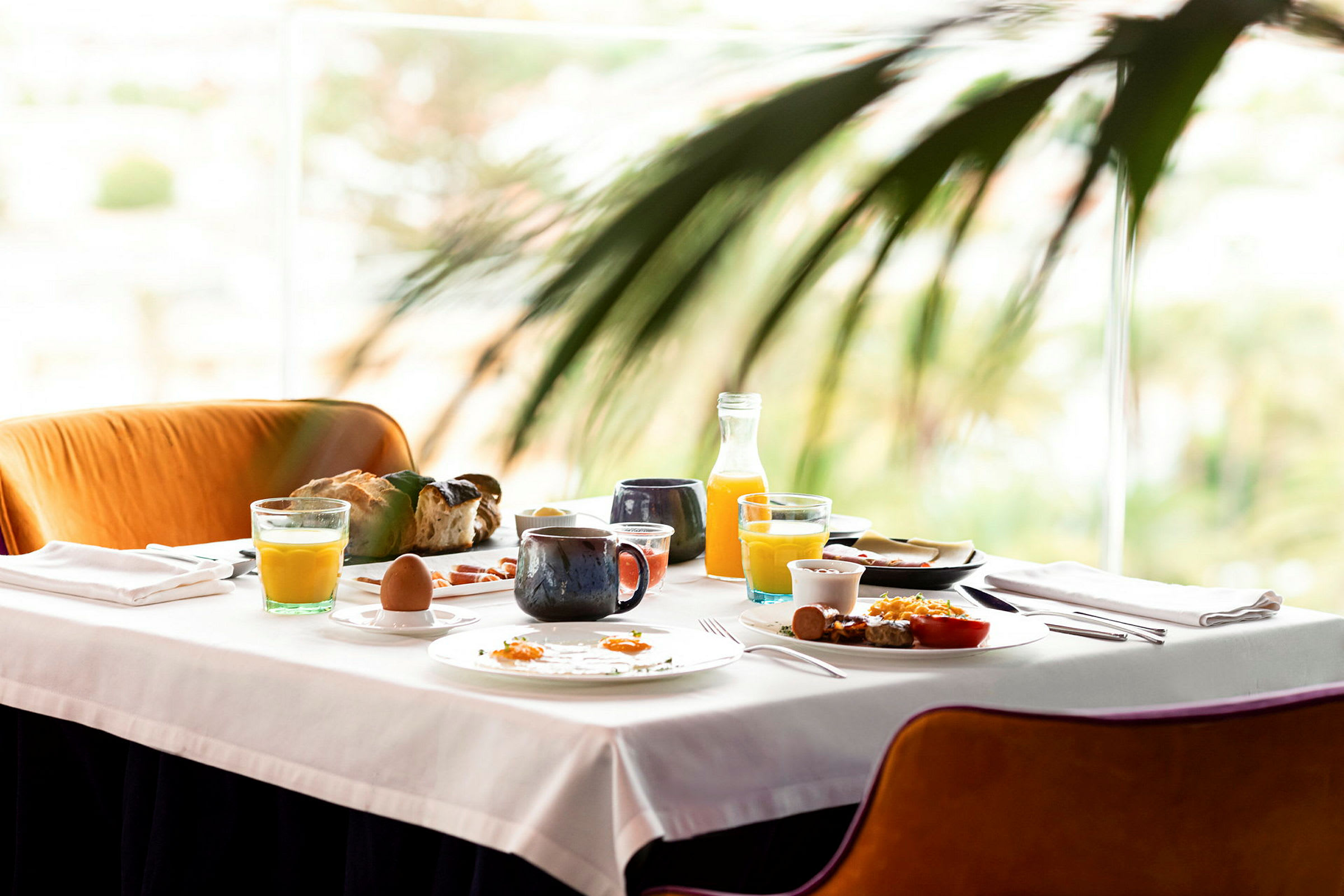 Ett bord dukat med frukostmat, inklusive juice, kaffe, bröd och ägg. (AI-genererad text)