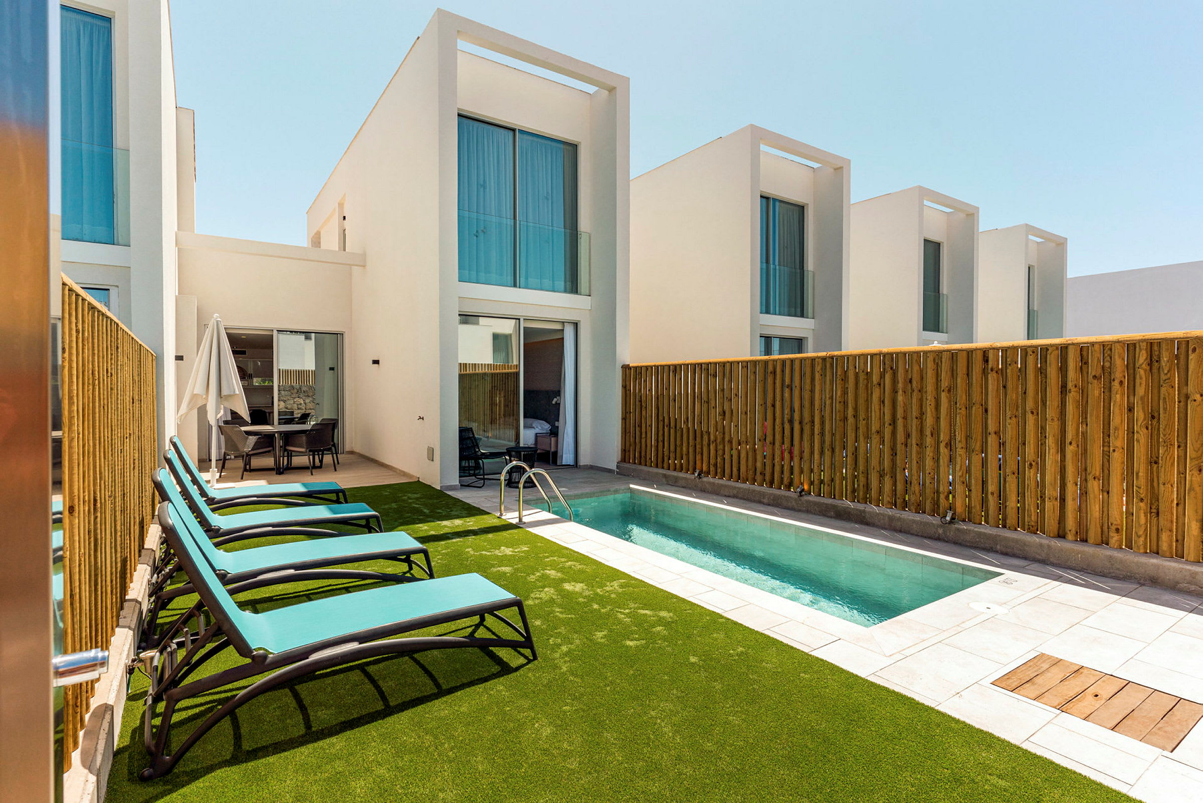 Privata villor med pool och solstolar. (AI-genererad text)