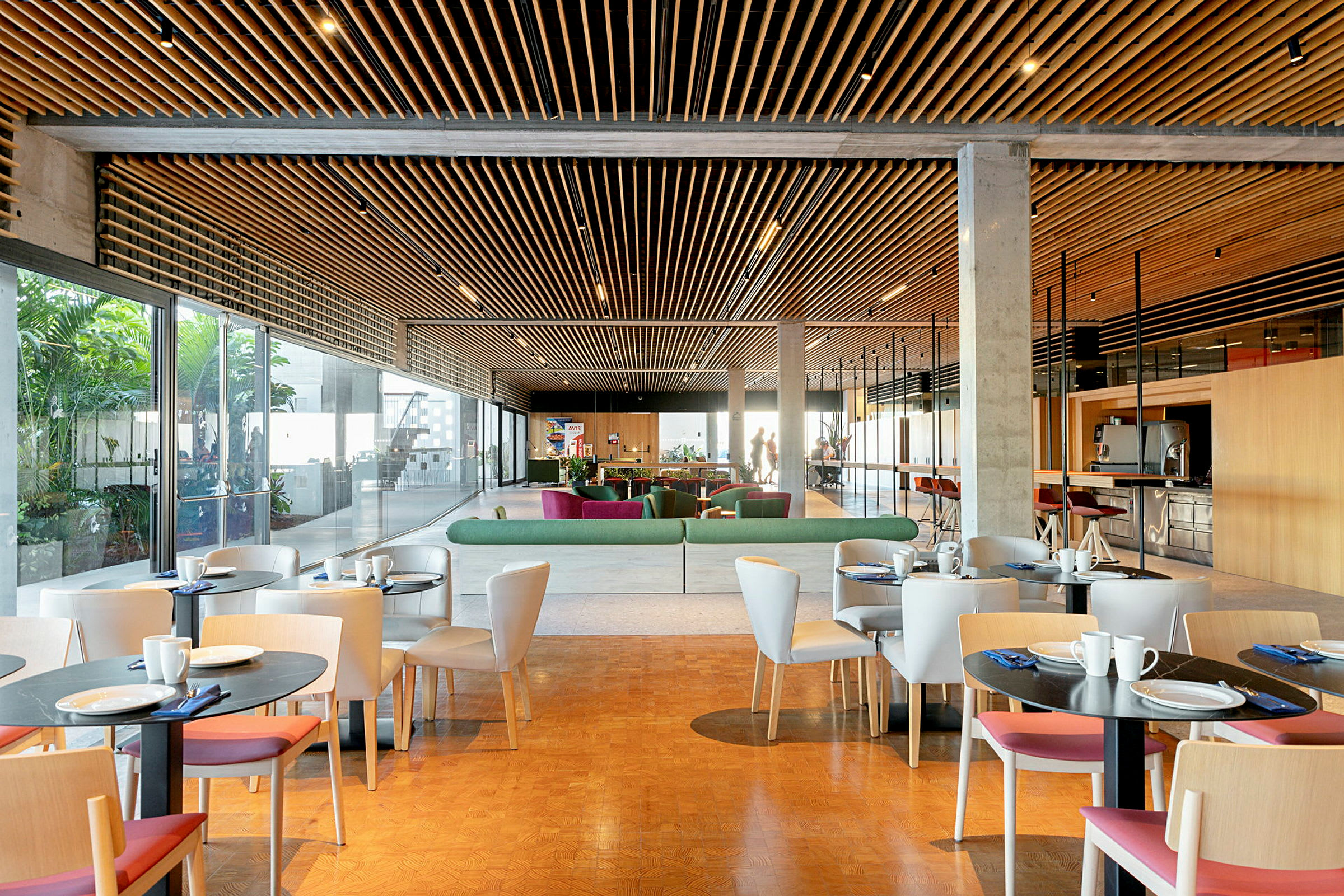 En modern lounge med bord och stolar, soffor och ett glastak. (AI-genererad text)