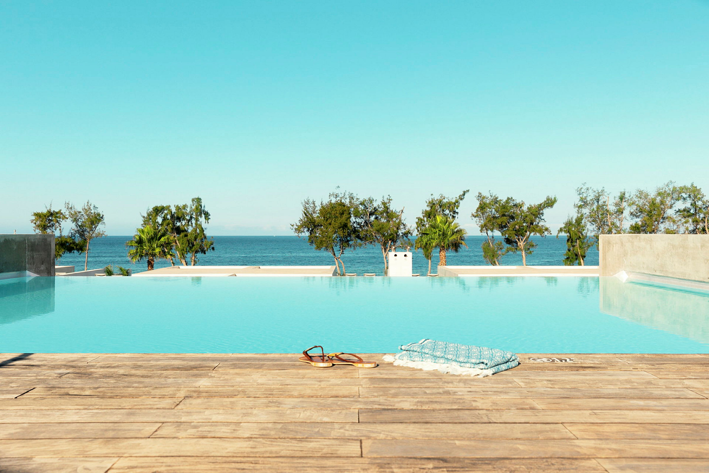 Bild av en infinitypool med utsikt över havet och träd i bakgrunden. (AI-genererad text)