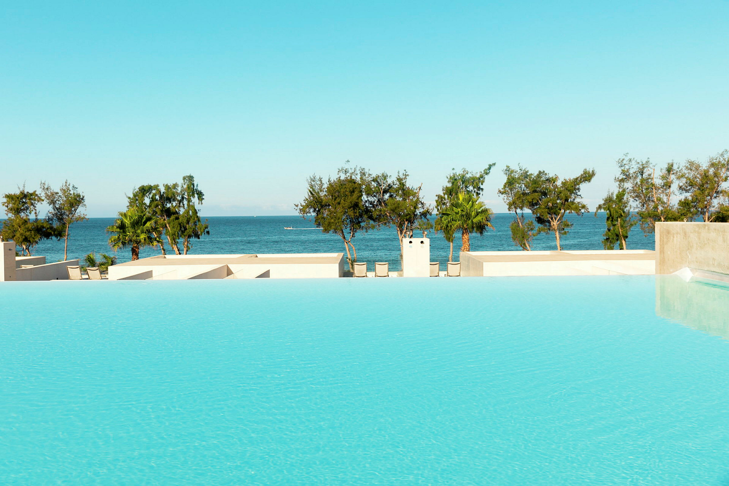 Infinitypool med utsikt över havet och palmträd. (AI-genererad text)