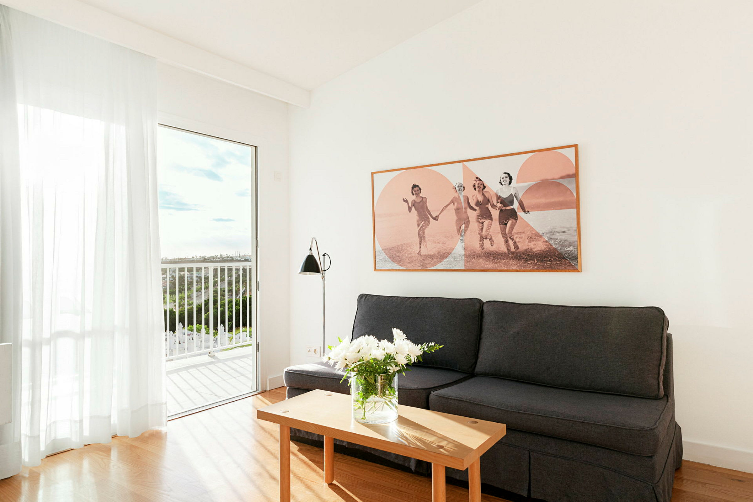 Ett vardagsrum med en soffa, ett soffbord och en tavla på väggen. (AI-genererad text)