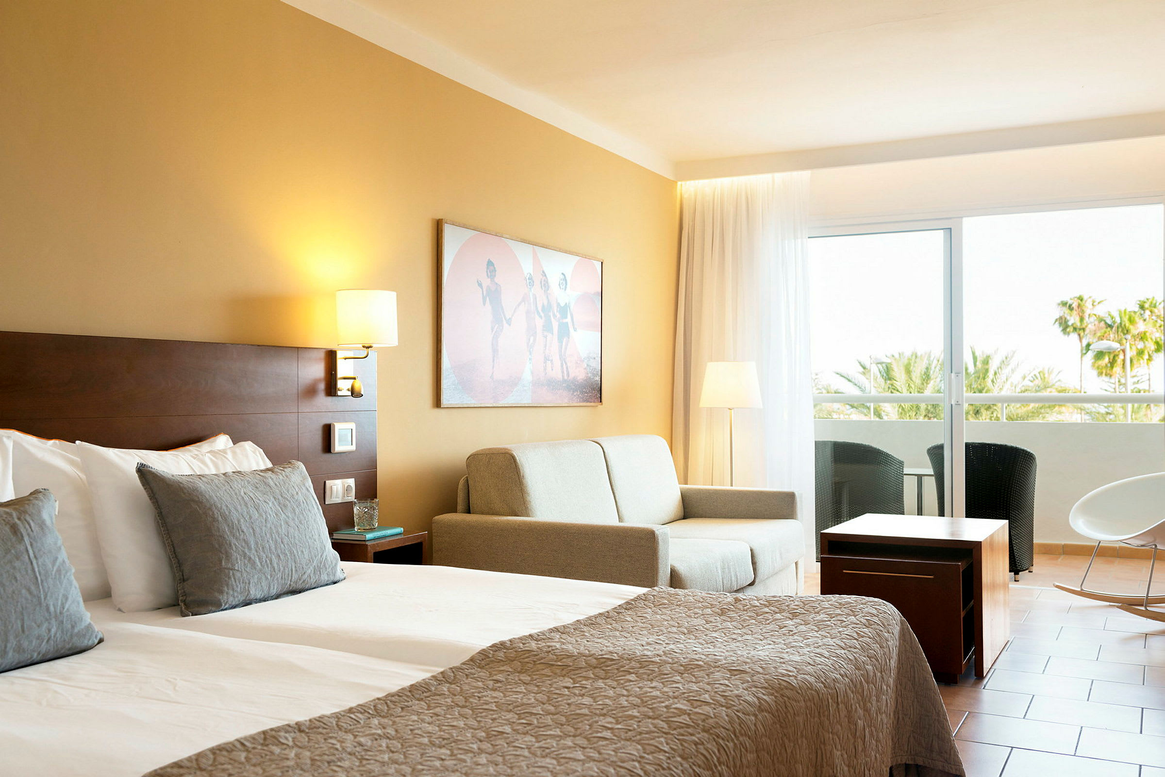 Hotellrum med dubbelsäng, soffa och balkong. (AI-genererad text)