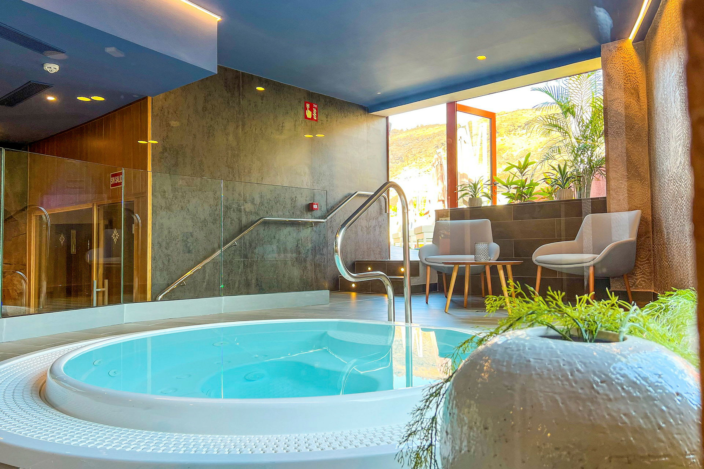 Inomhusspa med en bubbelpool, sittmöbler och växter. (AI-genererad text)