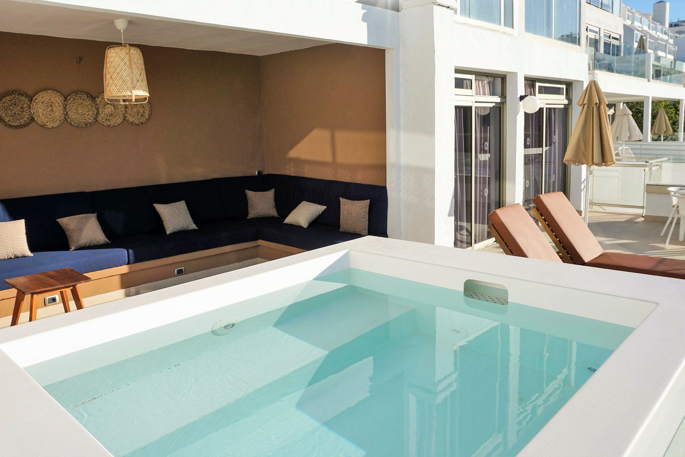 Utomhusområde med pool, solstolar och en sittgrupp med soffor. (AI-genererad text)