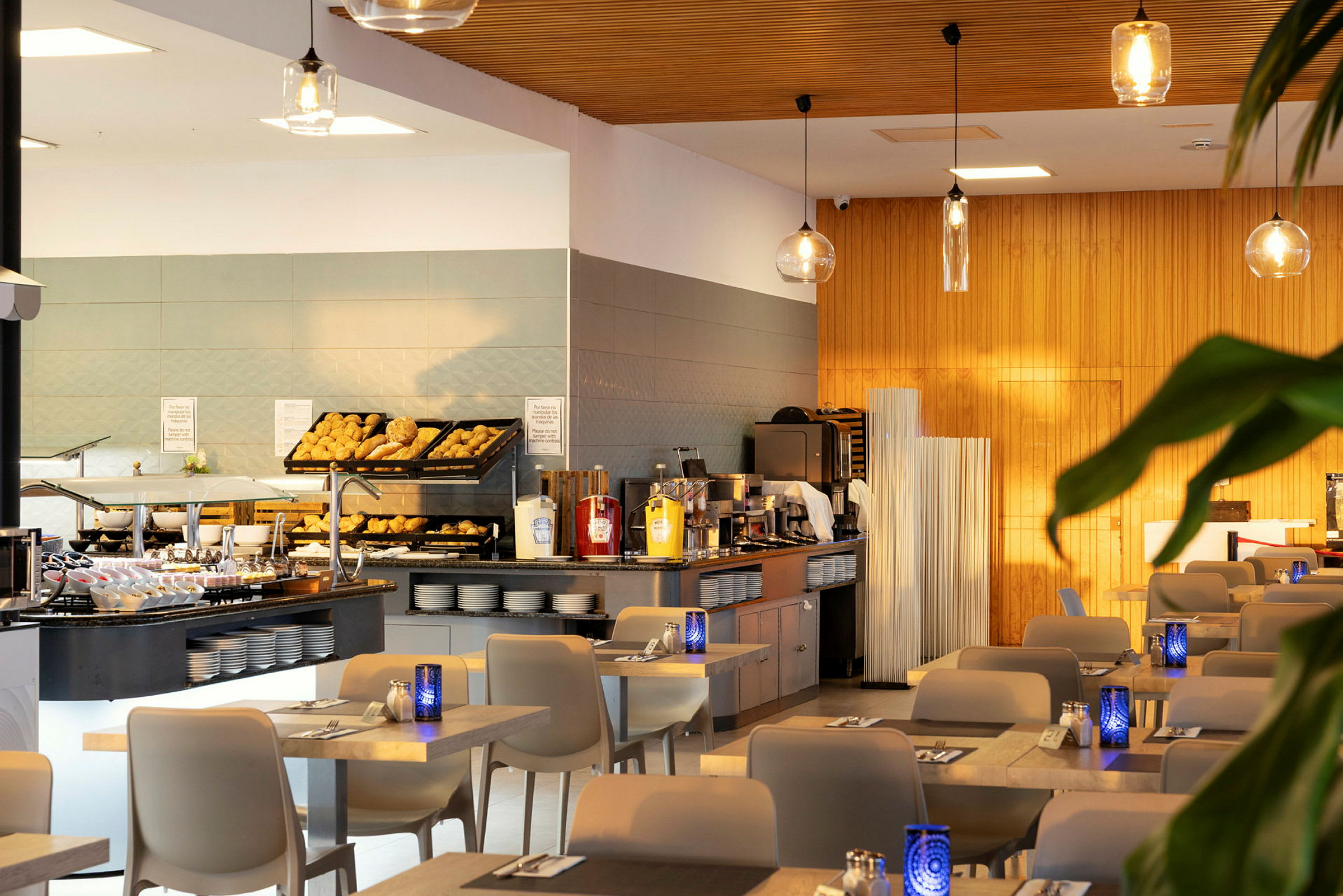Ett modernt hotellfrukostområde med uppställning av bröd och drycker. (AI-genererad text)