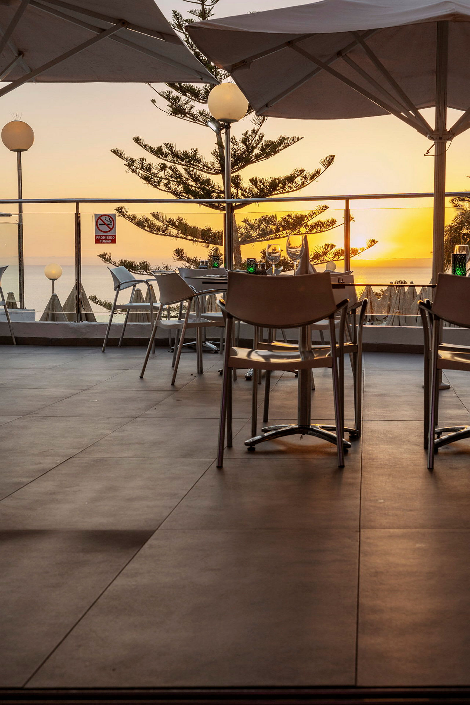 Restaurang med uteservering och havsutsikt vid solnedgång. (AI-genererad text)