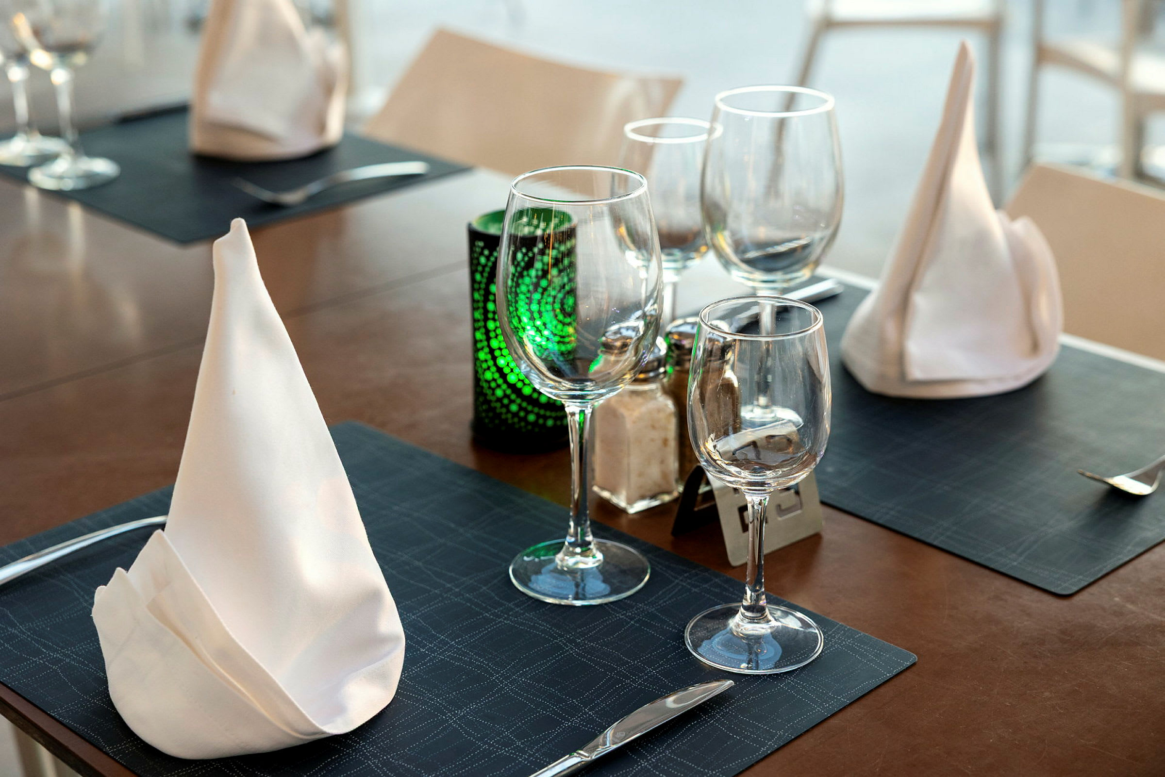 Dukat bord med glas, bestick och servetter. (AI-genererad text)